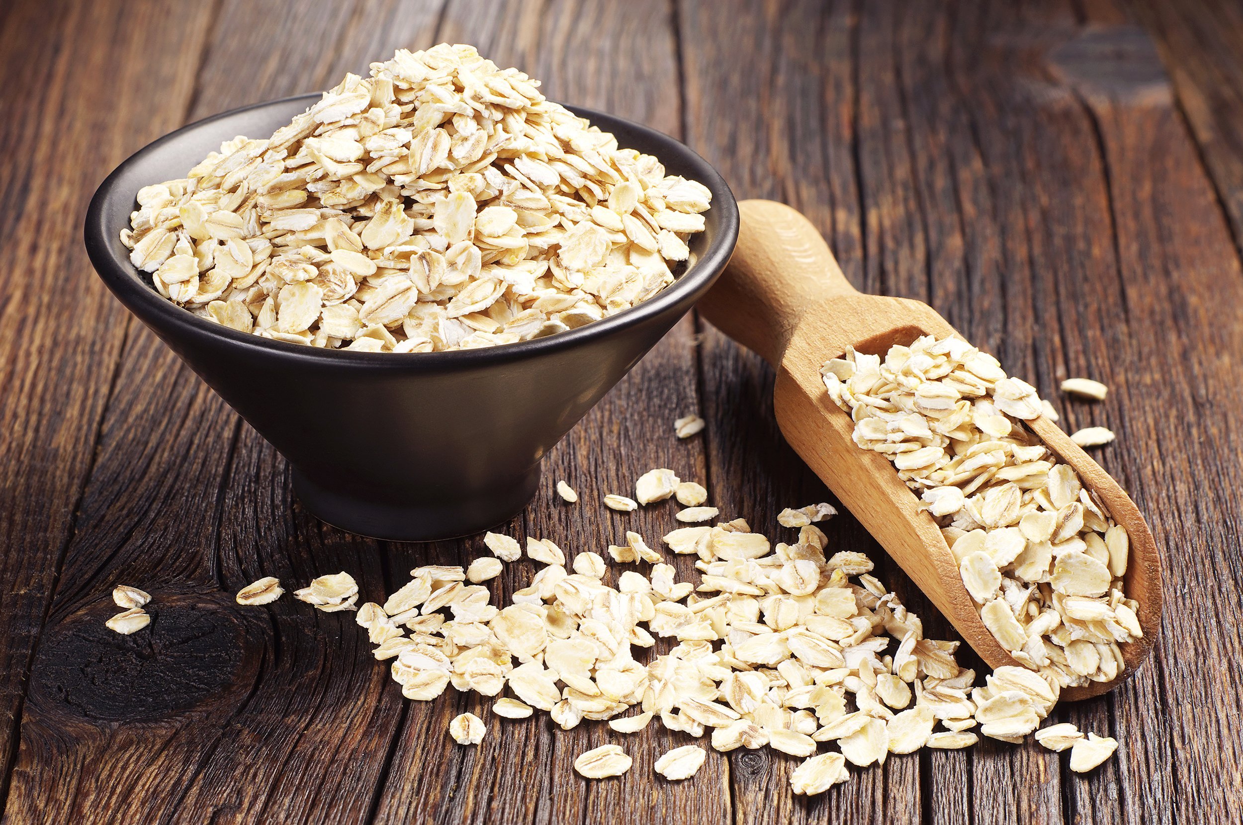 oat in bowl and scoop on dark wooden table