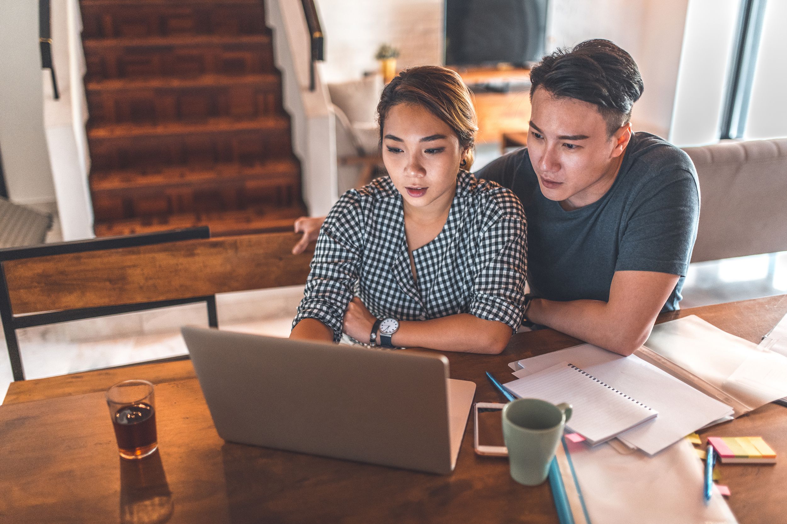serious couple using laptop while sitting at home