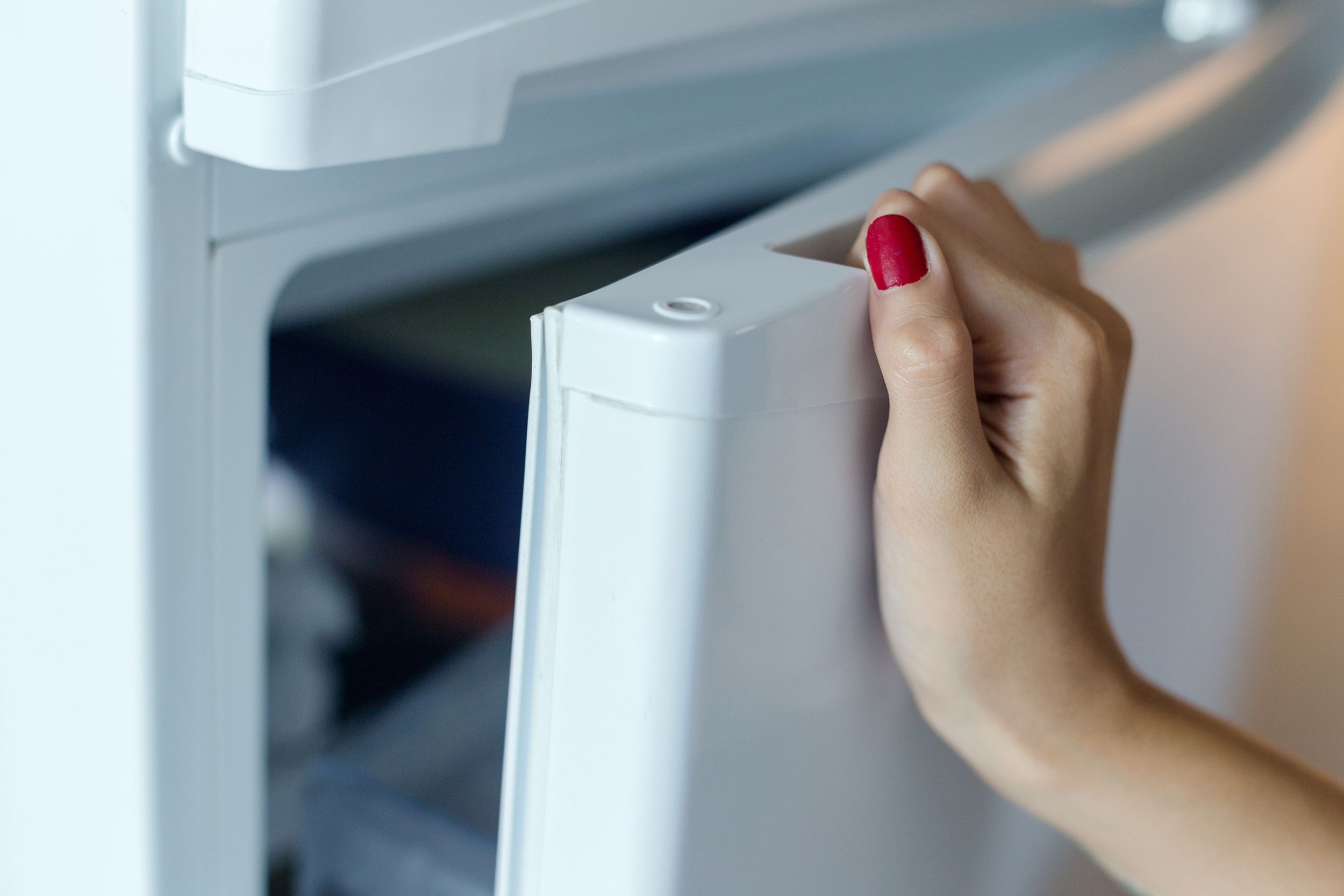 close up hand opens fridge