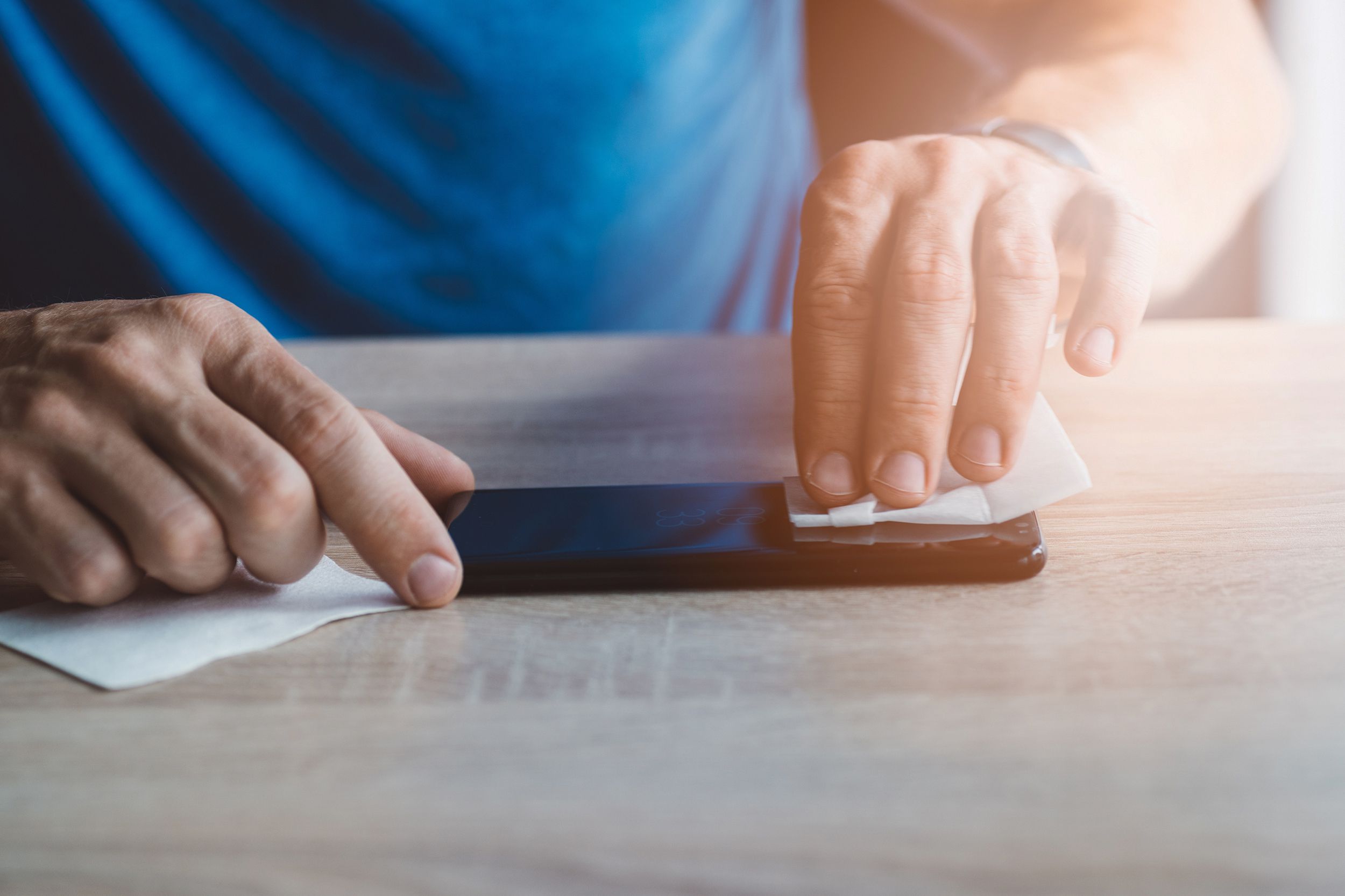 man cleaning smartphone screen with cloth