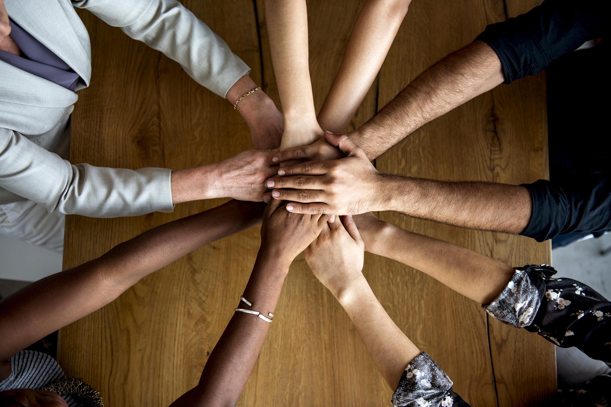 Employees with their hands together in collaboration