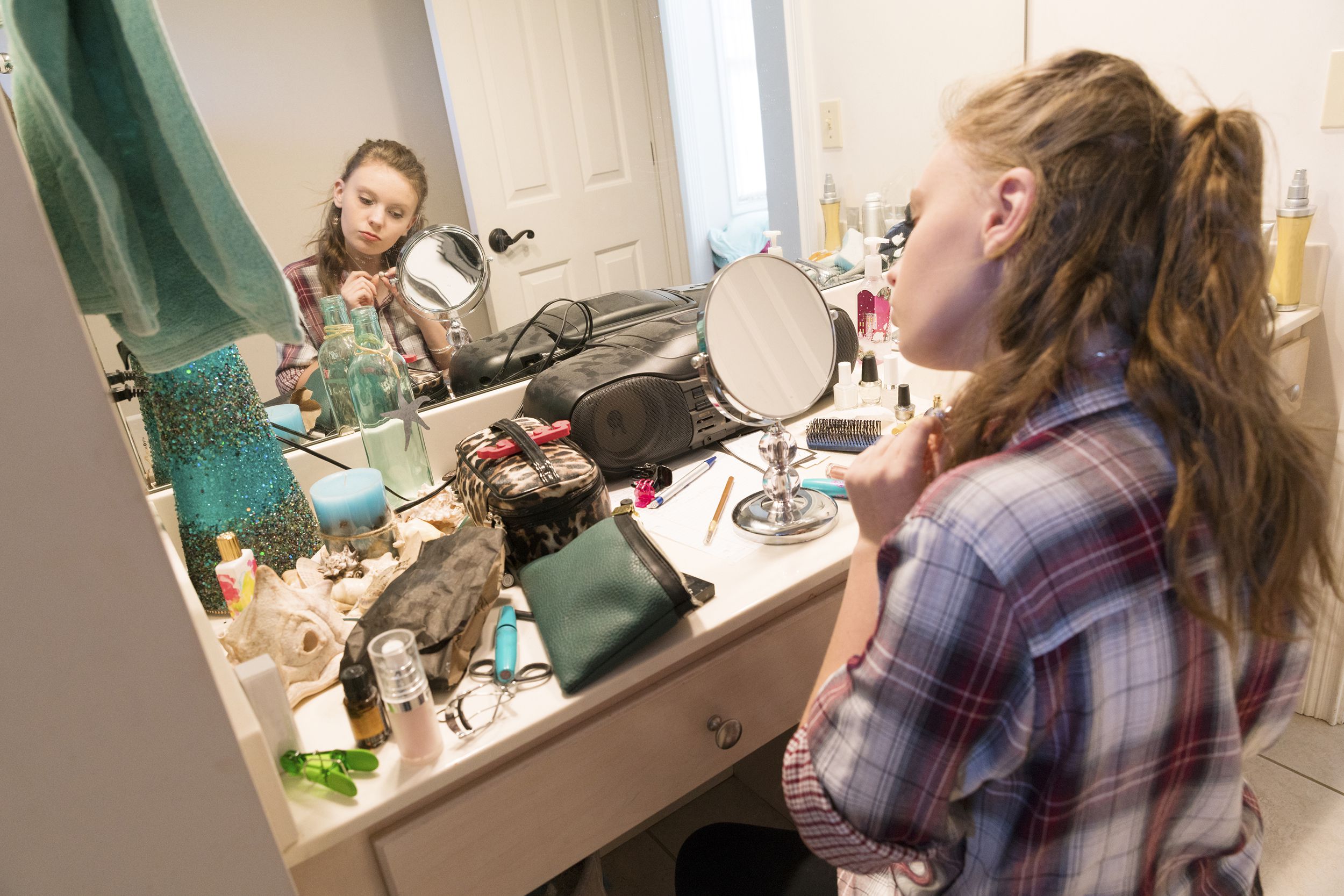 teenager doing makeup in bathroom
