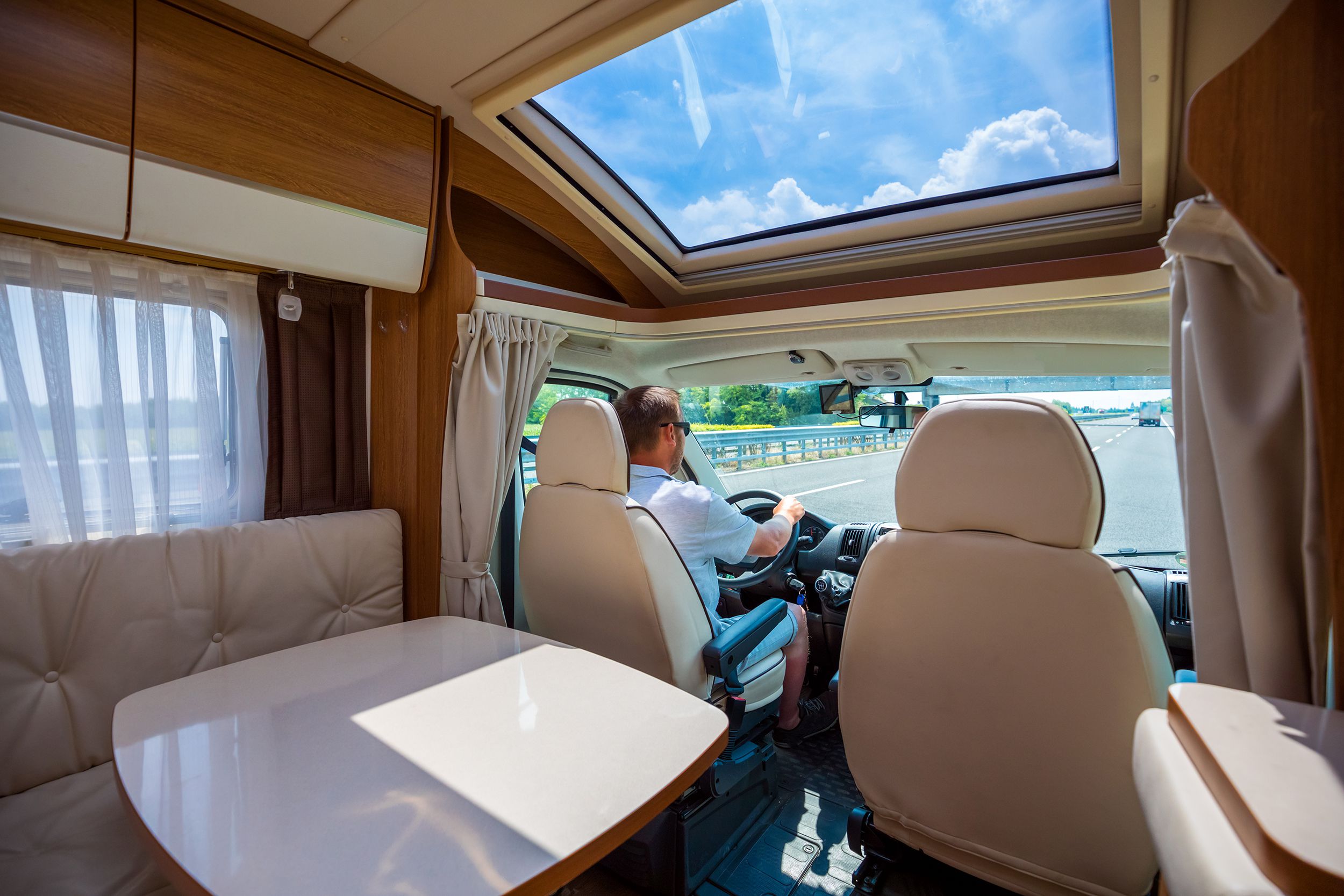 man driving on a road in the camper van