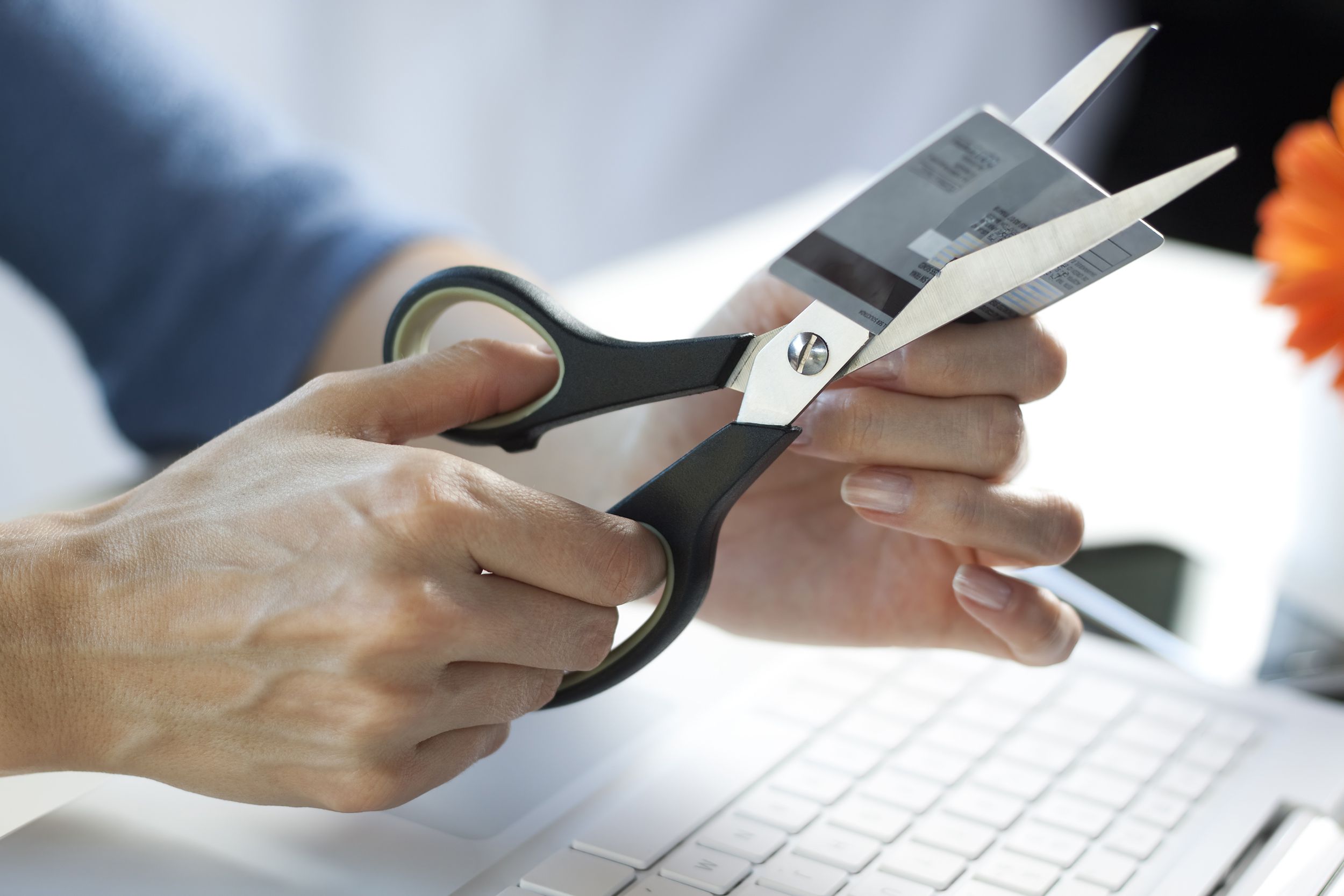 hands with scissors cutting credit card