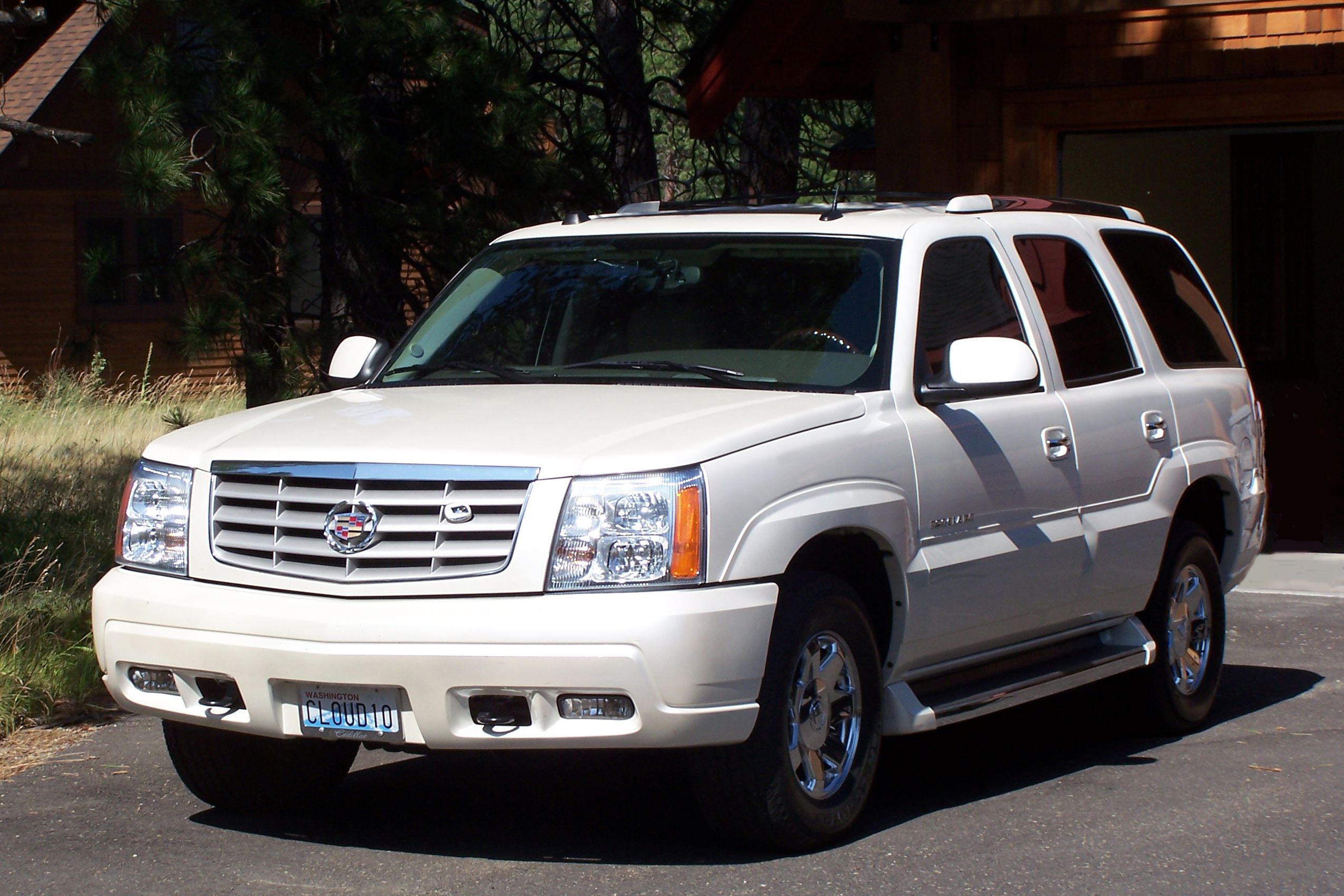 White 2005 Cadillac Escalade parked in driveway on summer day.