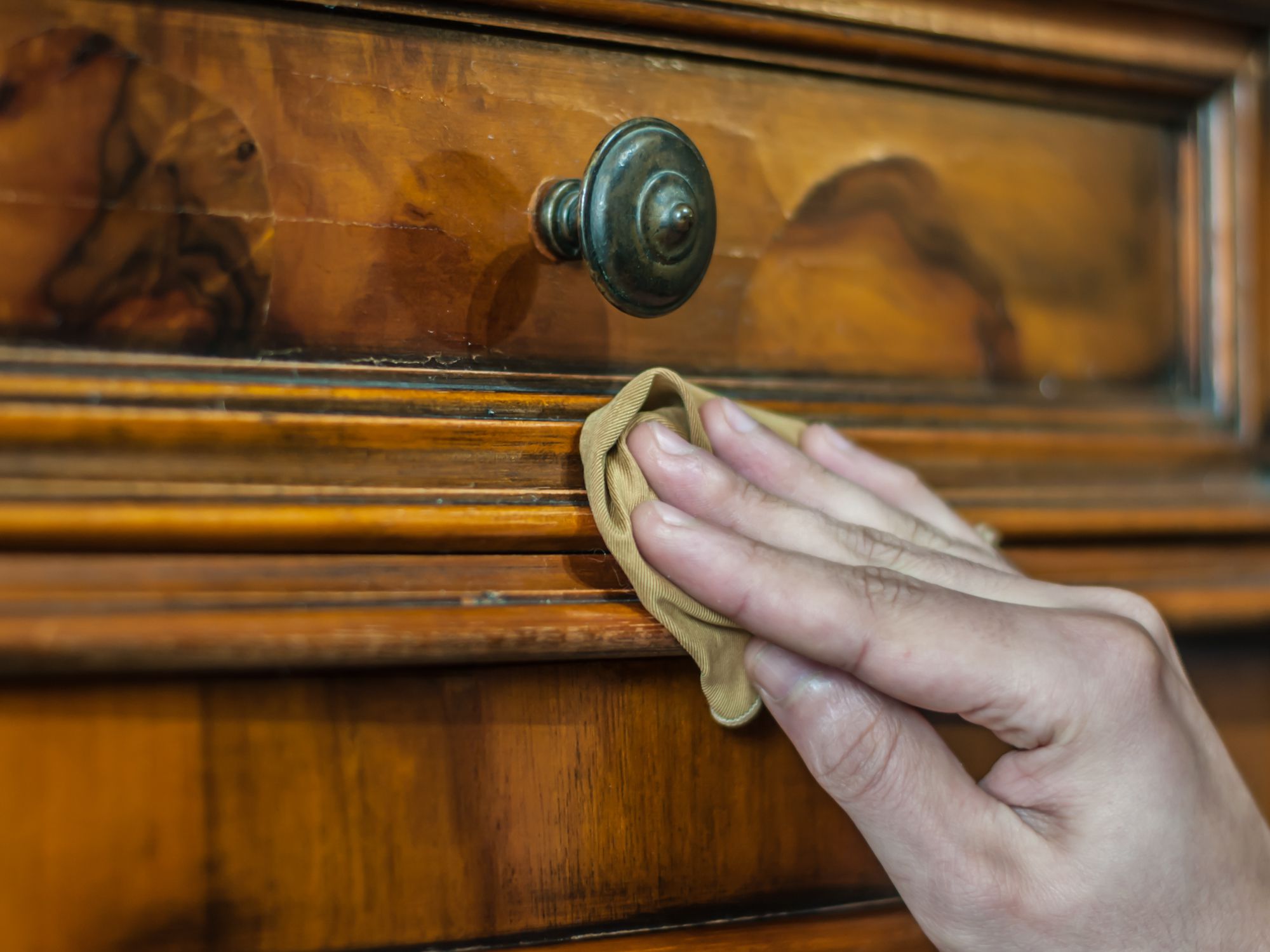 Hand applying oil and wax on a old wood furniture