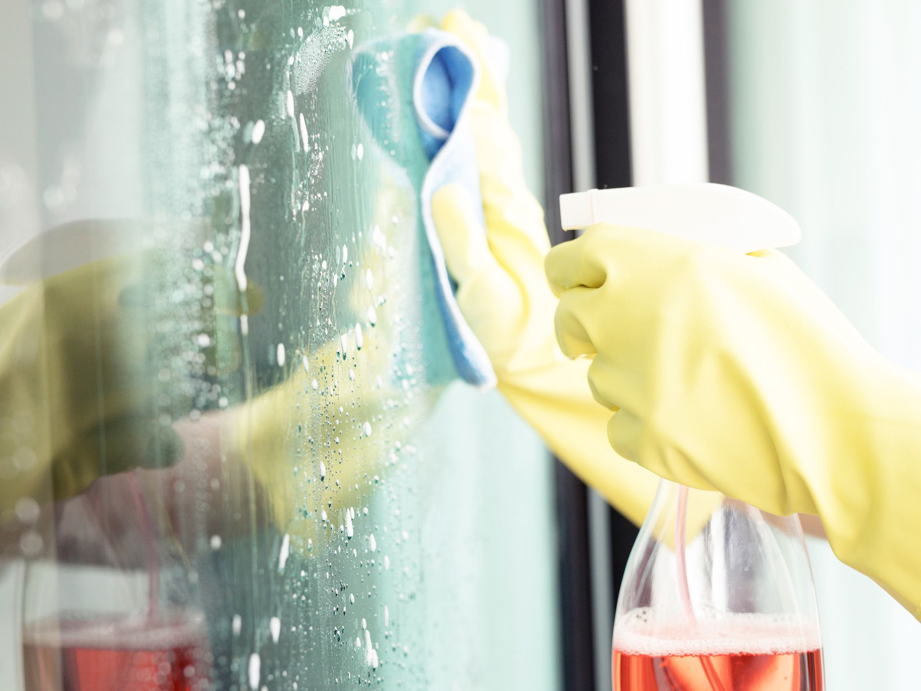 Staff are cleaning aluminum glass doors. To protect against Covid 19 virus and bacteria