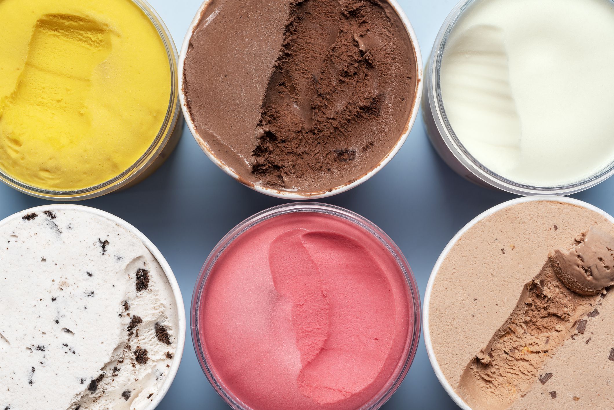 Top view with various types of ice cream. Containers with different kinds of ice cream and sorbet, above view.