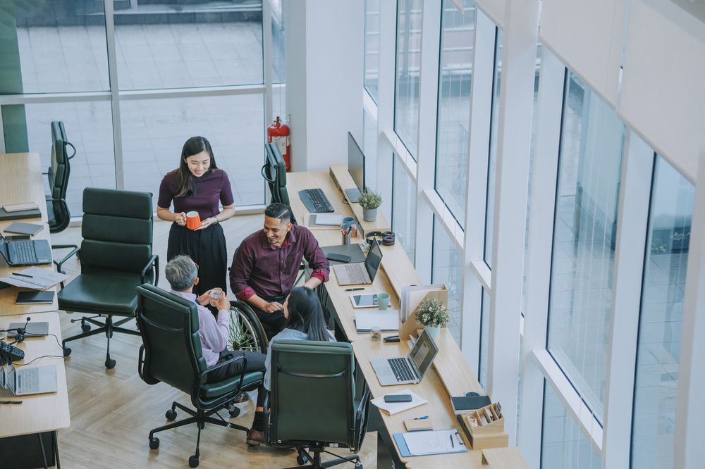 Group of Asian white collar worker having a break taking snack at the workstation office together