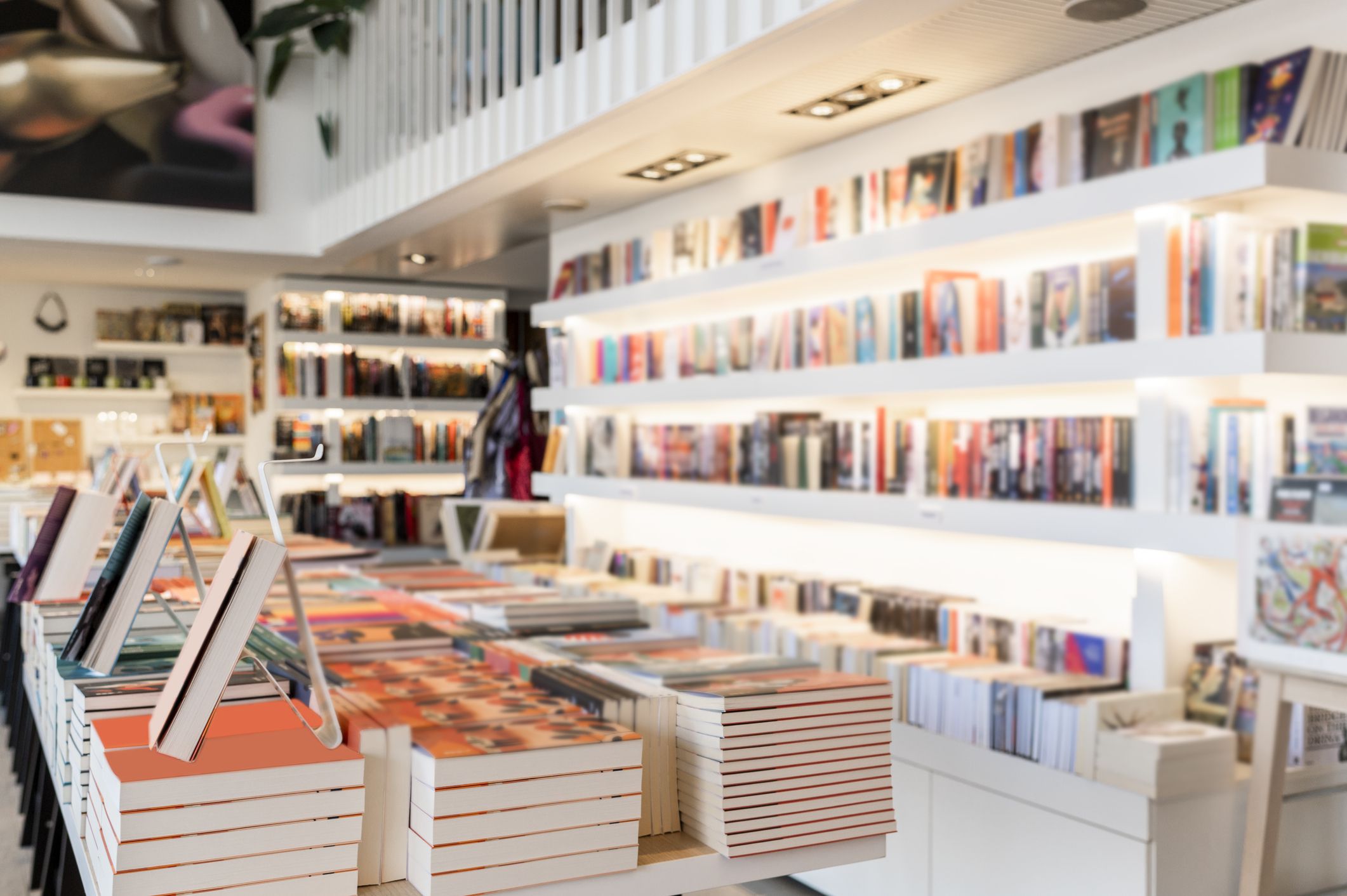Very modern and bright bookstore with white shelves full of books seen during day light.