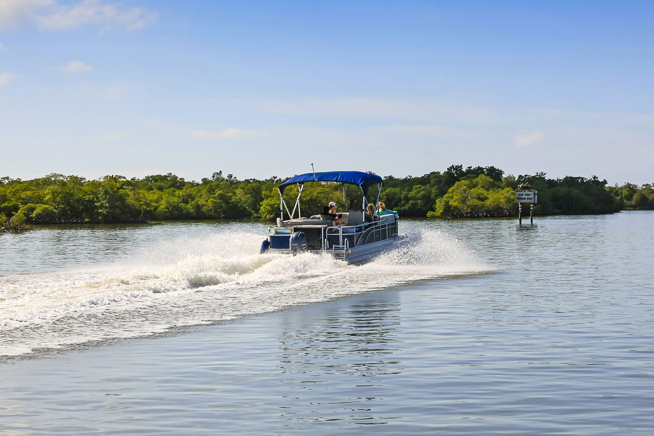 Naples, FL, USA - March 16, 2016: People enjoying a day out in a Pontoon boat in Haldeman Creek in Naples, Florida
