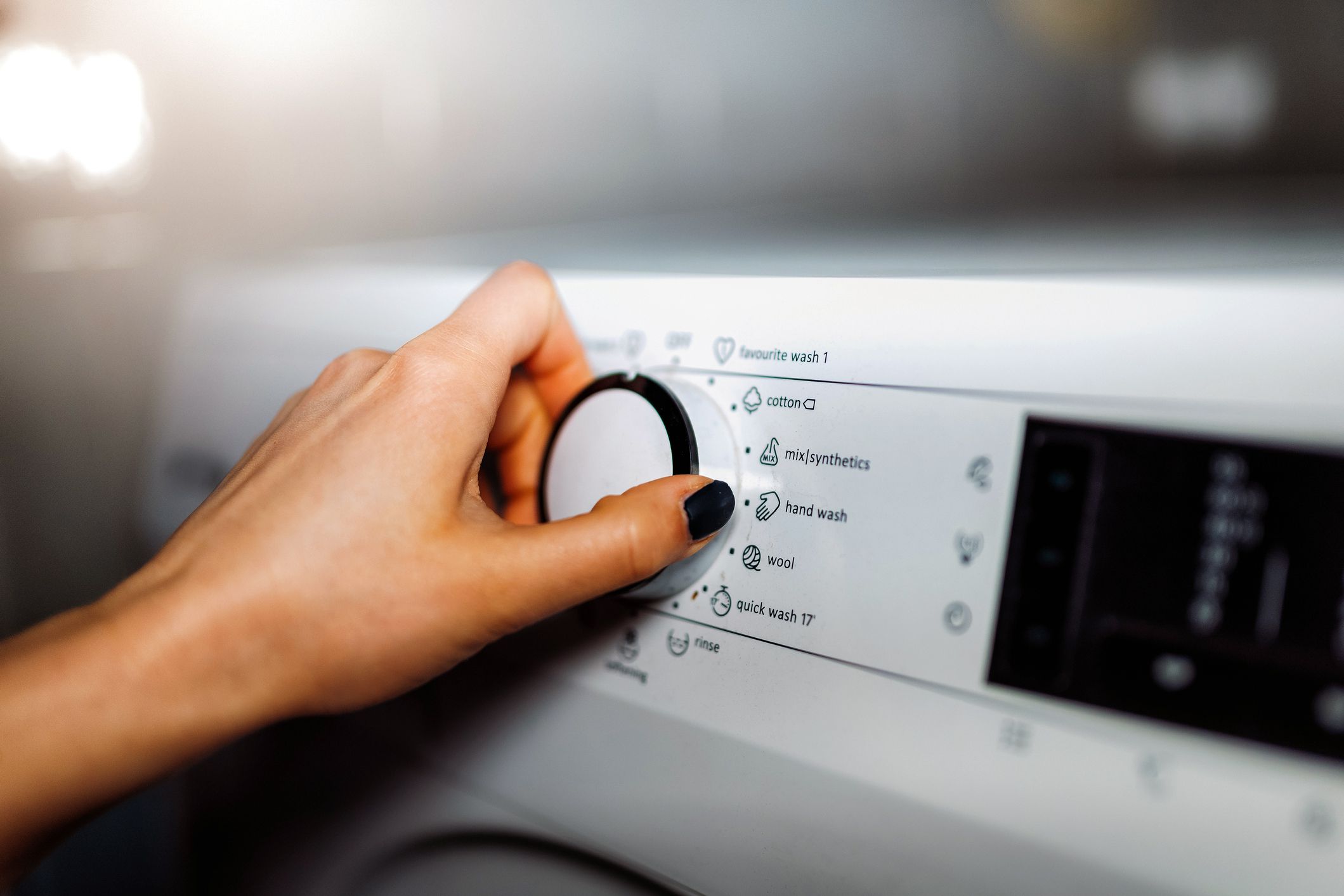 hands choosing washer setting