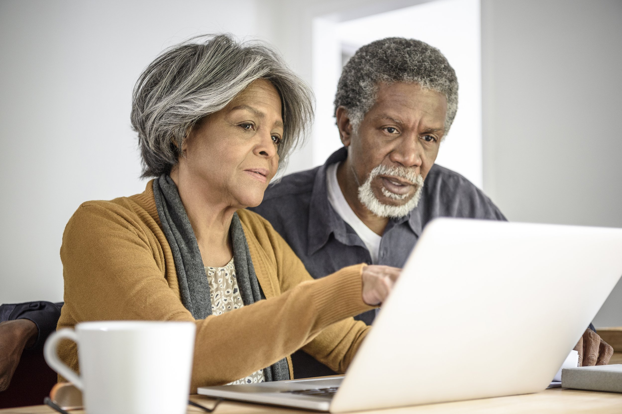 senior African American couple on laptop together with serious expression