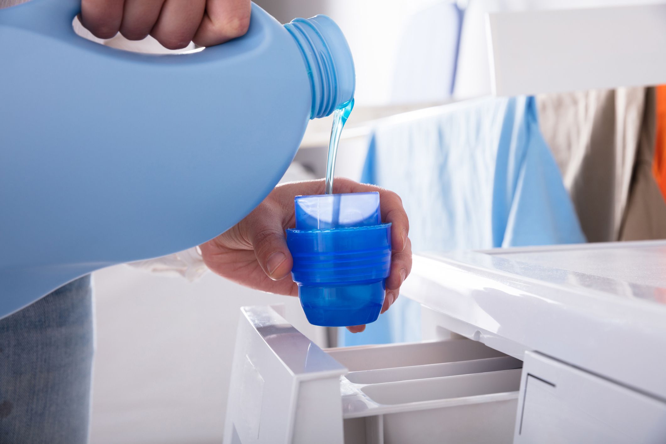 hands pouring detergent