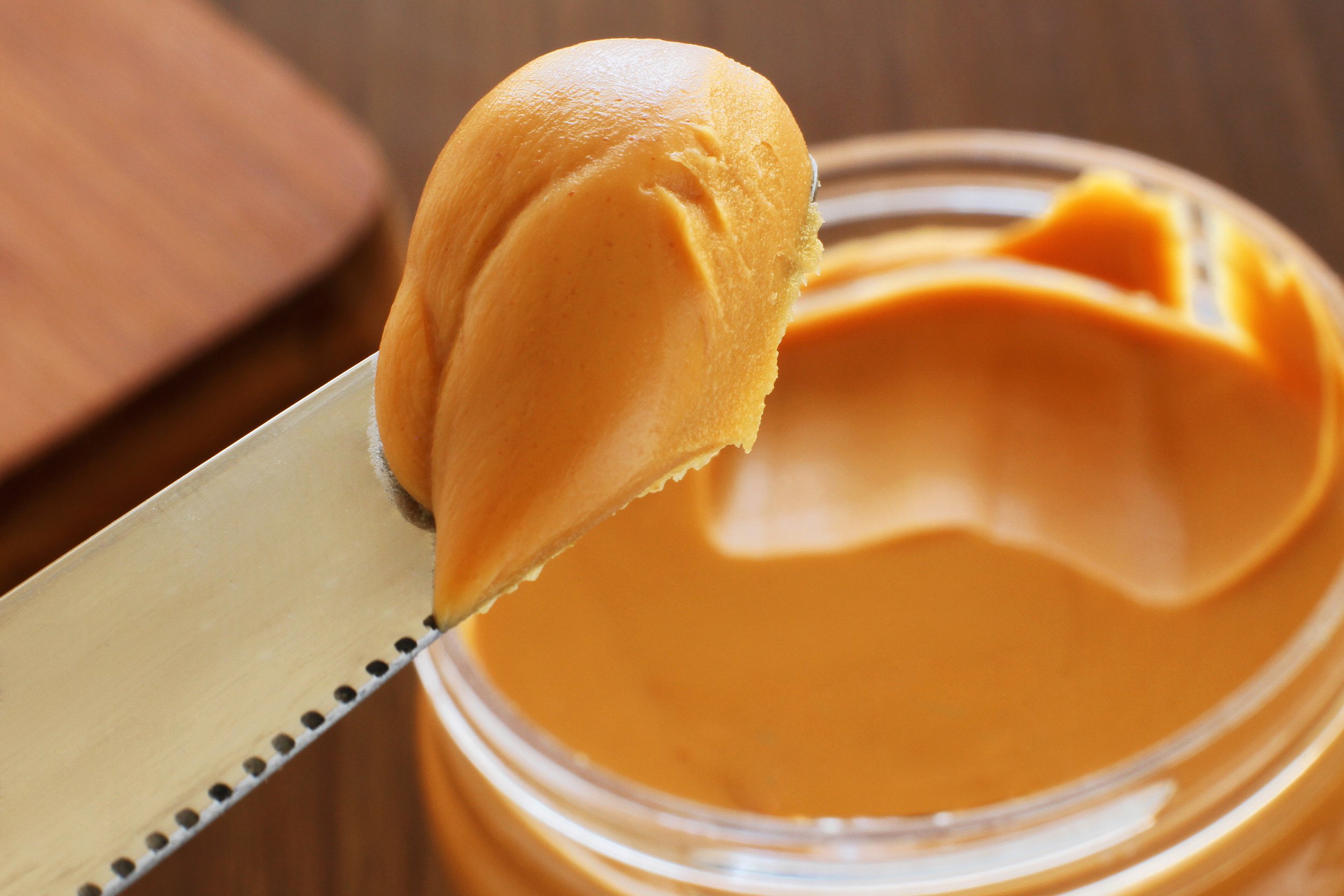peanut butter jar and knife holding some of it