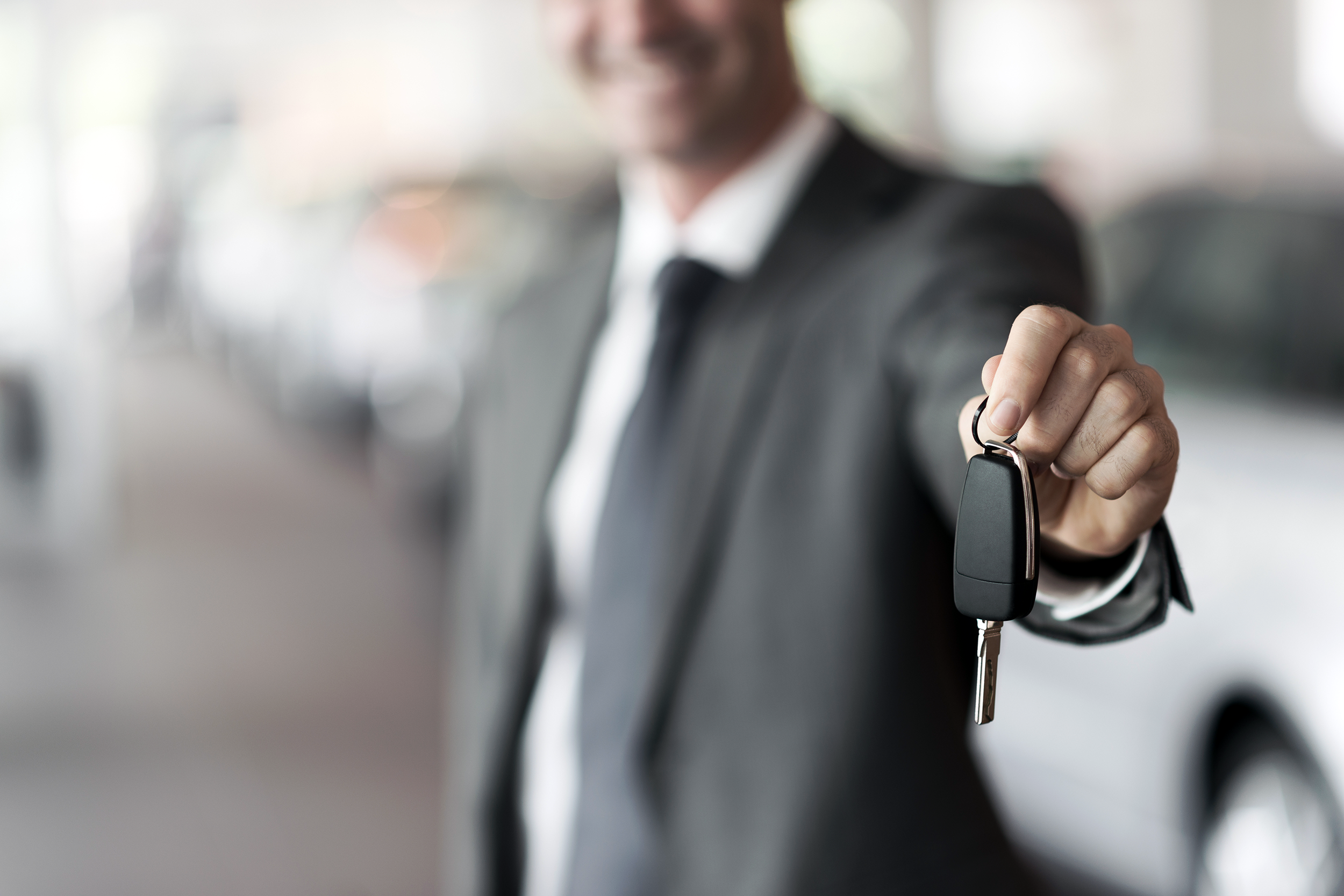 Man holding out keys to a rental car