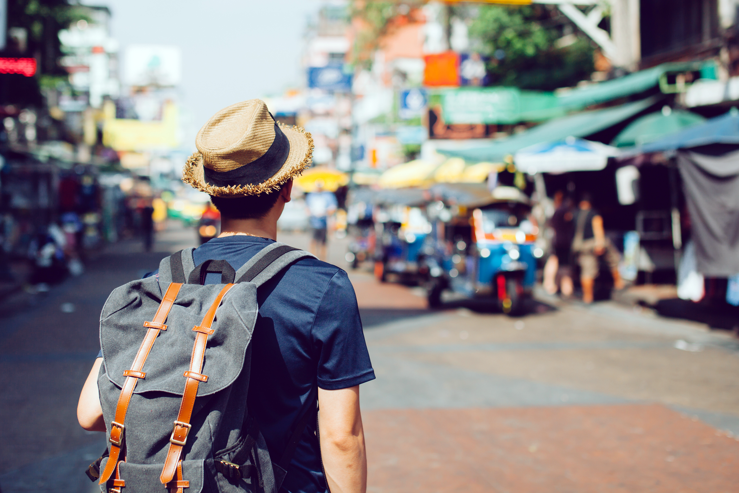 Man wearing a backpack looking at outdoor market