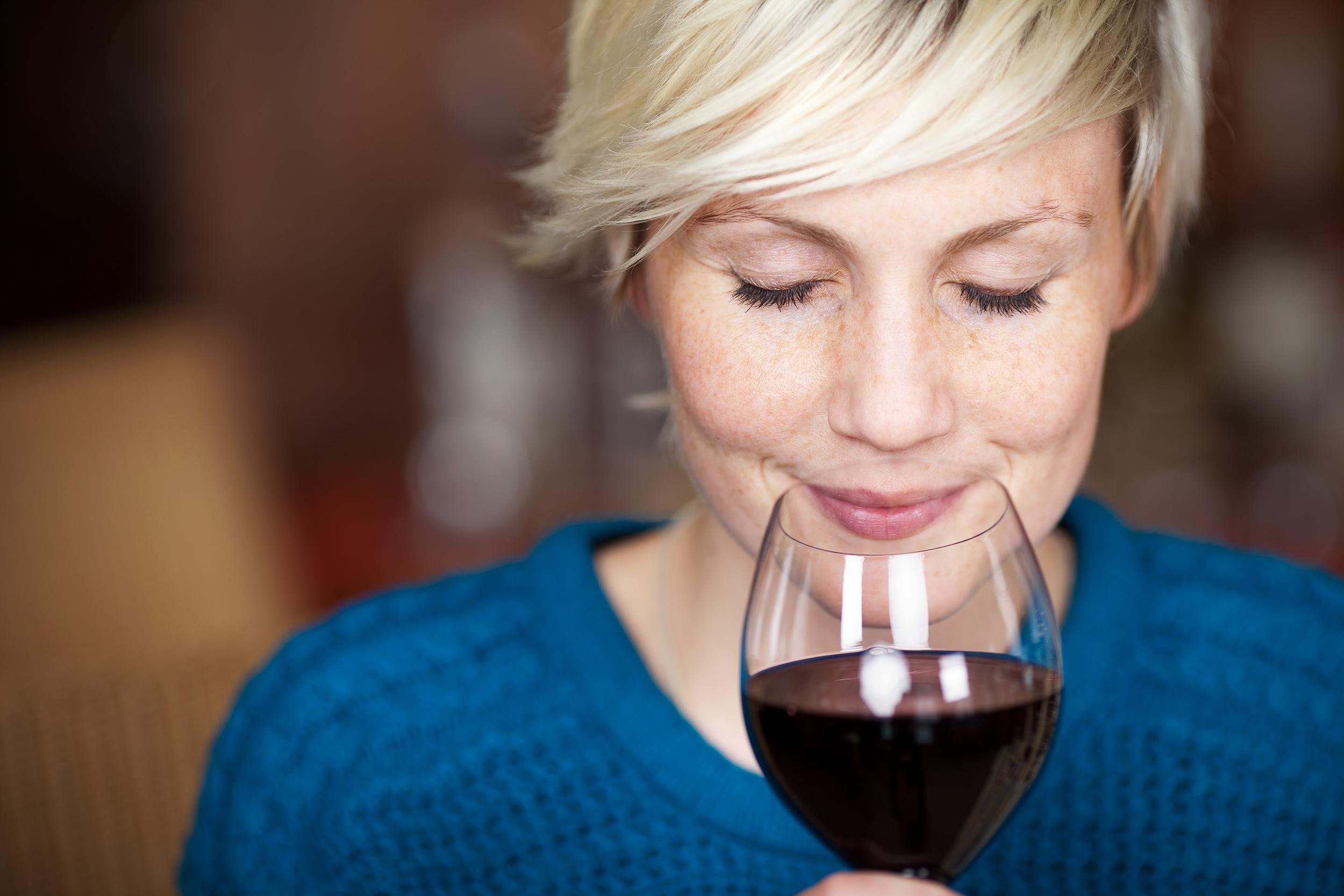 female customer drinking red wine with eyes closed
