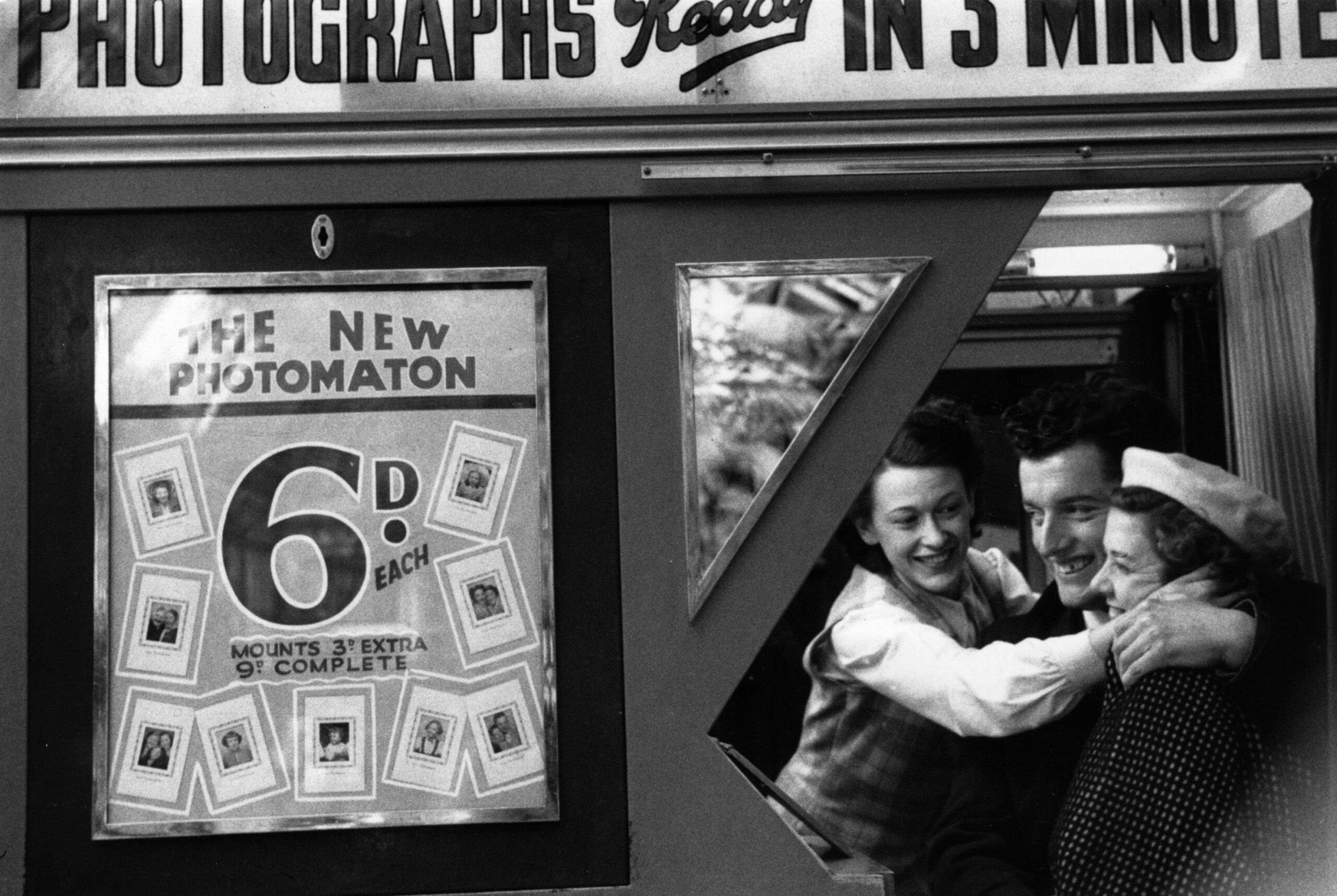 Three friends crammed into the Photomaton photo booth in 1953