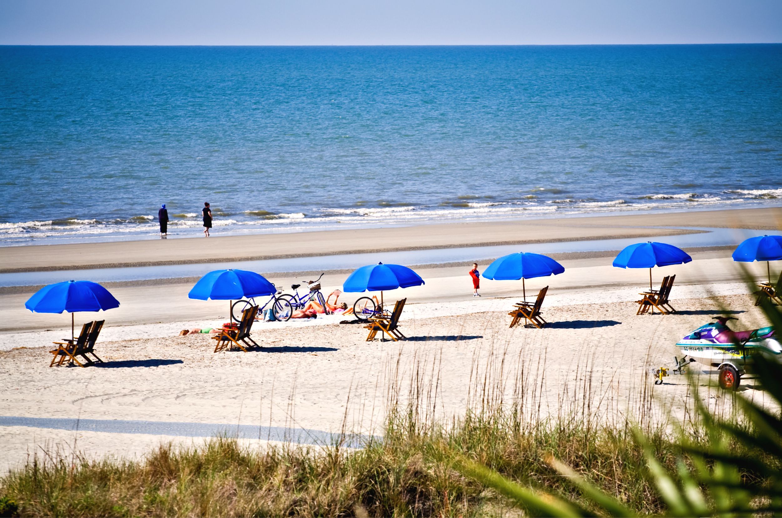 Beach chairs under blue umbrellas at Hilton Head Island, SC