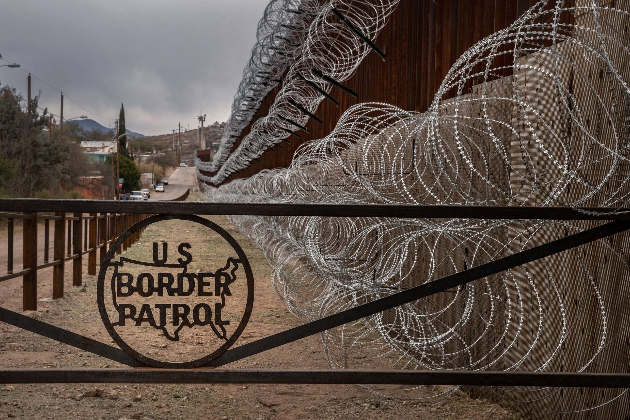 A metal fence marked with the US Border Patrol sign prevents people to get close to the barbed/concertina wire covering the US/Mexico border fence, in Nogales, Arizona, on February 9, 2019.