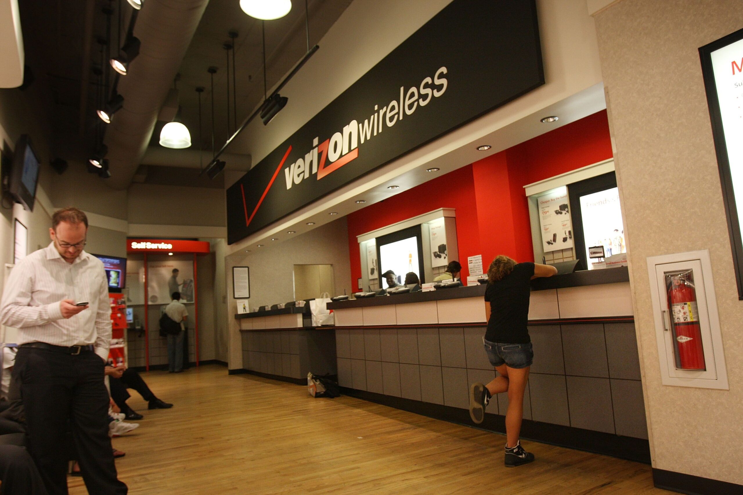 People wait for service inside a Verizon store July 27, 2009 in New York City.