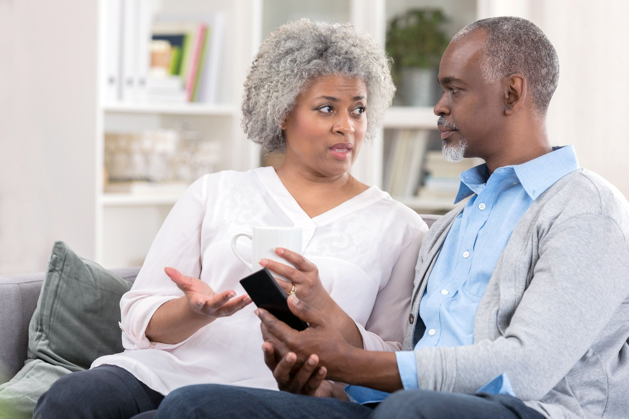 senior couple having serious discussion on couch