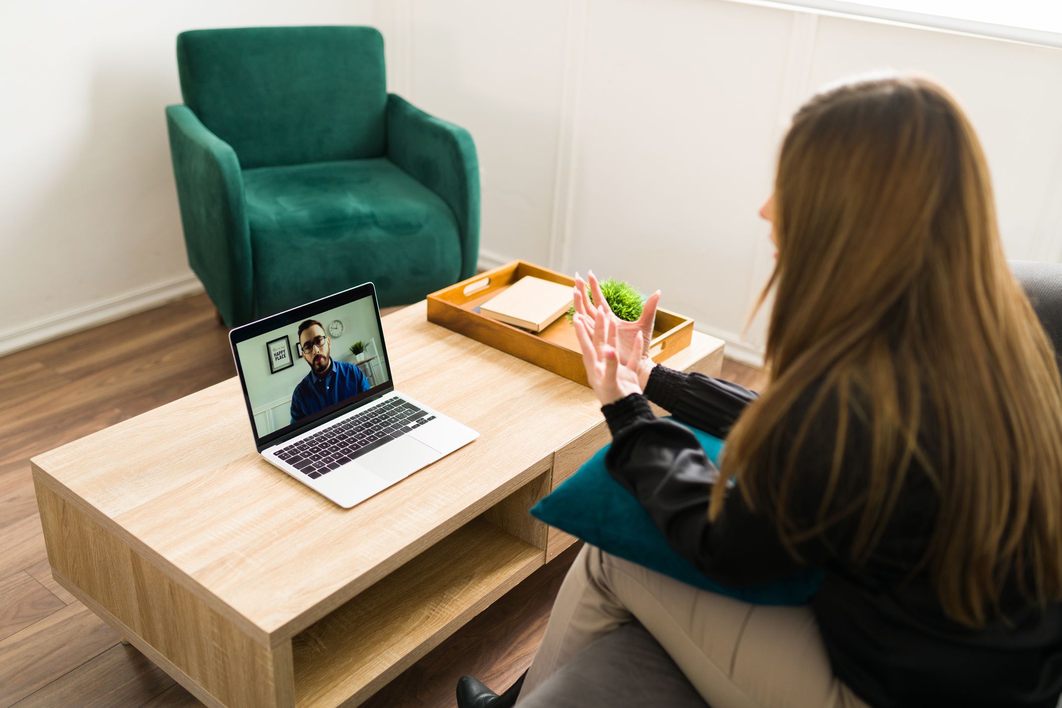 Troubled woman speaking about her personal problems with a psychologist during virtual therapy