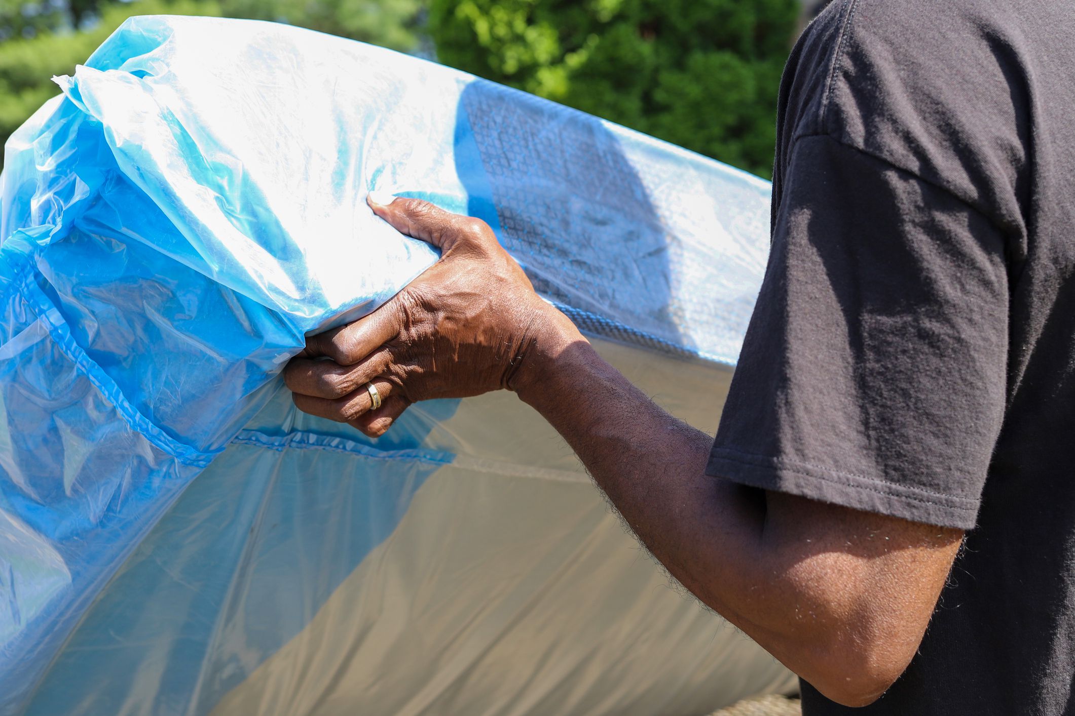 A black African-American man delivering a new mattress