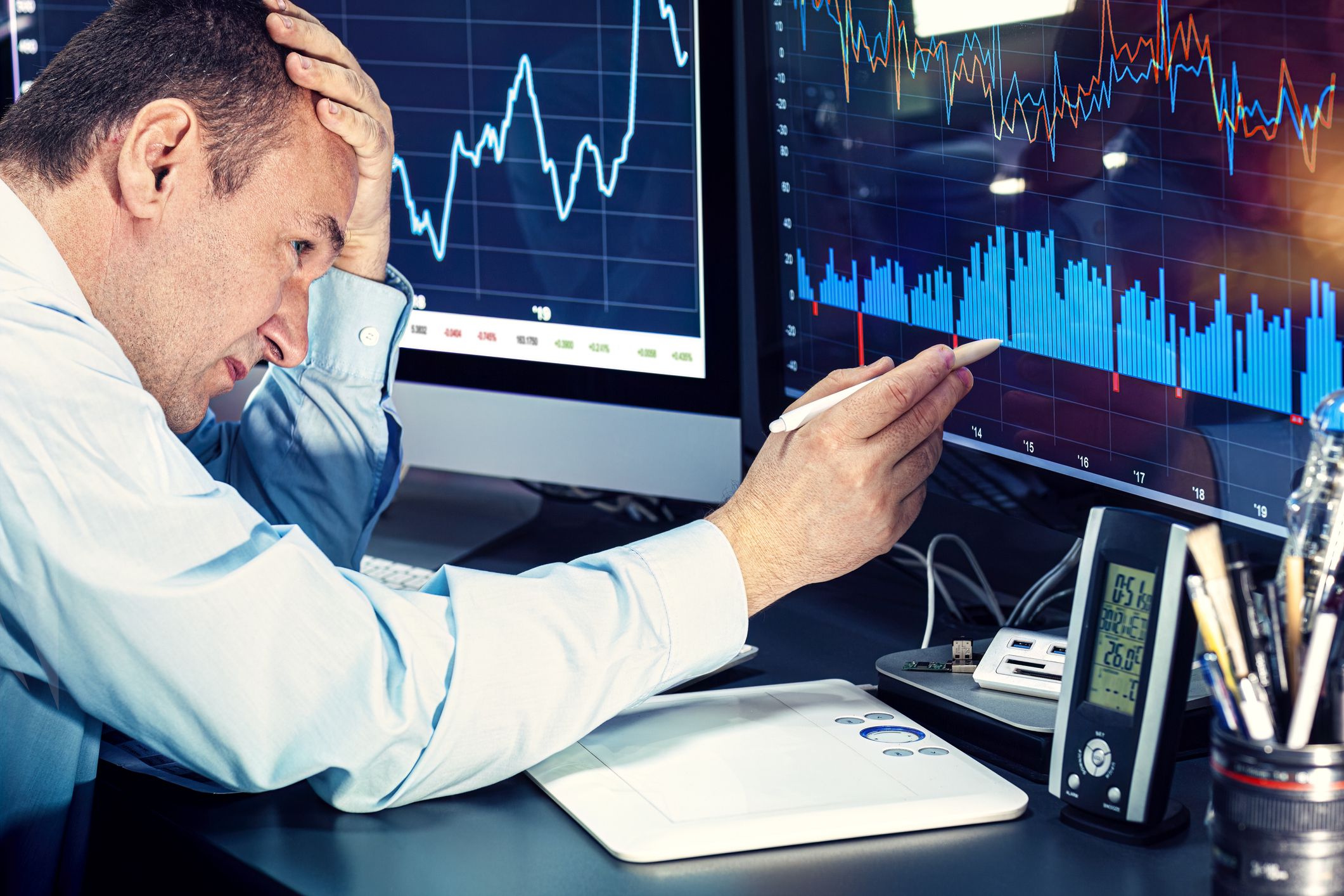 The economist analyzes the charts on the computer monitor.