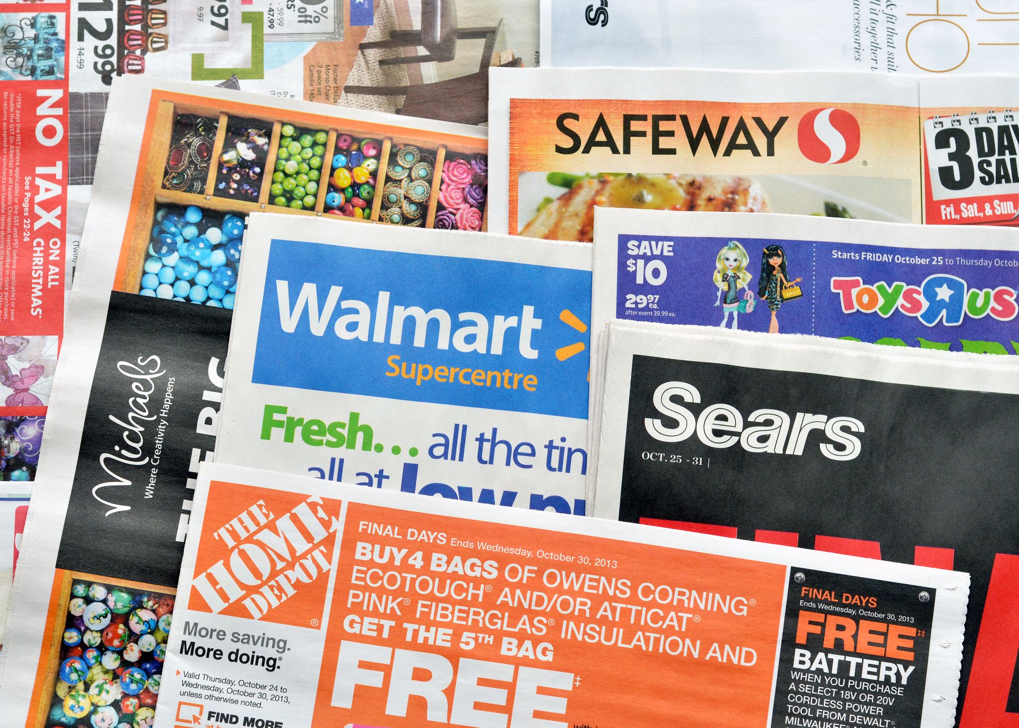 Vancouver, Canada -- October 23, 2013:Close up of a pile of weekly retail advertisements from major retailers such as Walmart, the Home Depot, Sears, Safeway and Michaels.