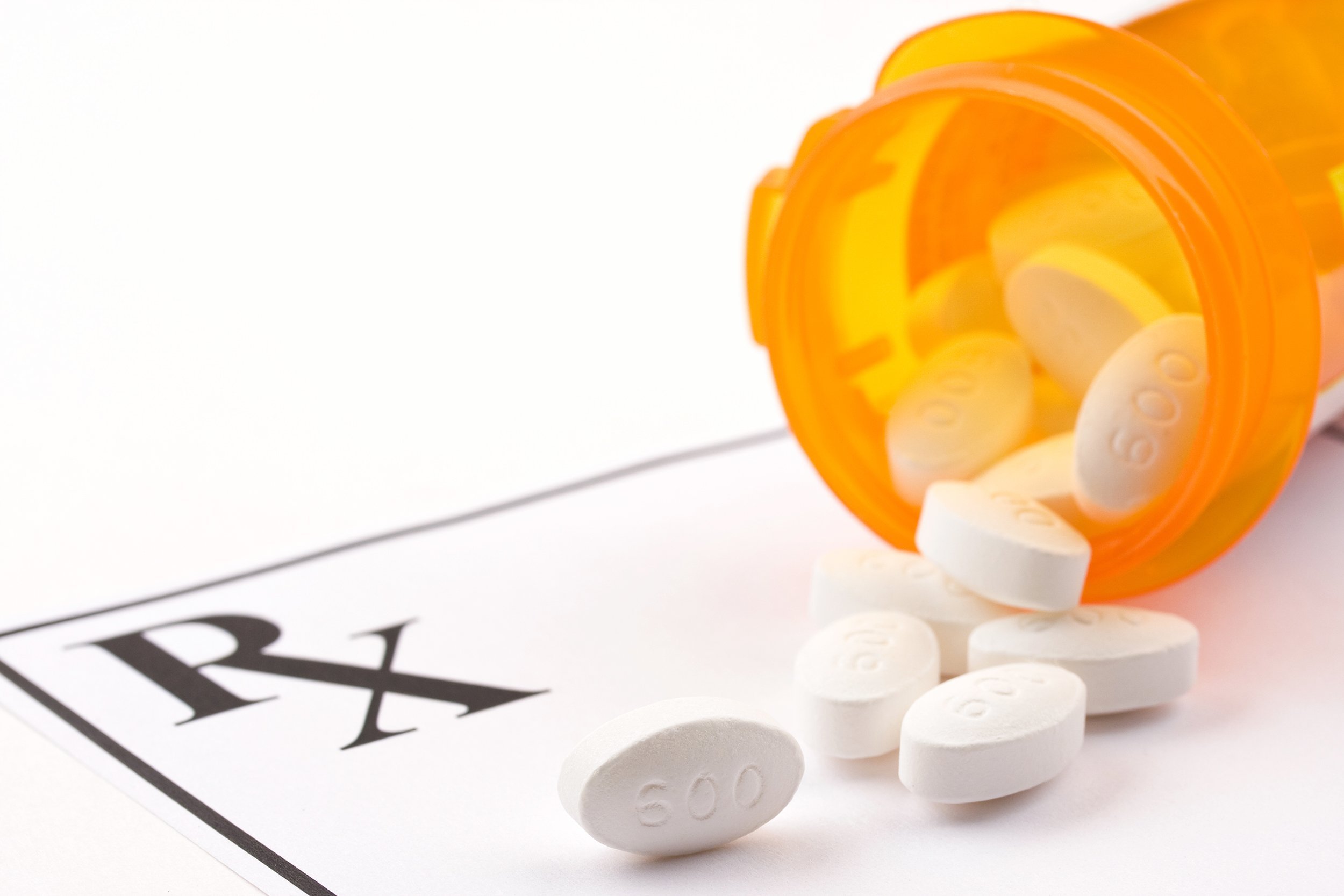 medicine bottle and pills laying on prescription