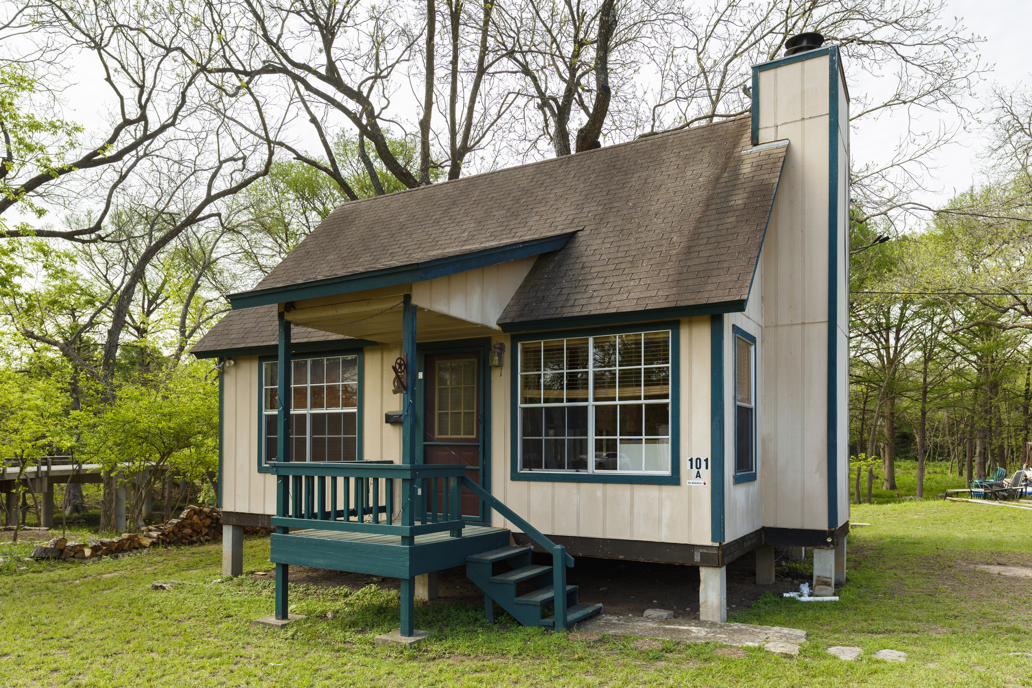 A tiny home in Wimberley, Texas with trees and yard surrounding it during early spring