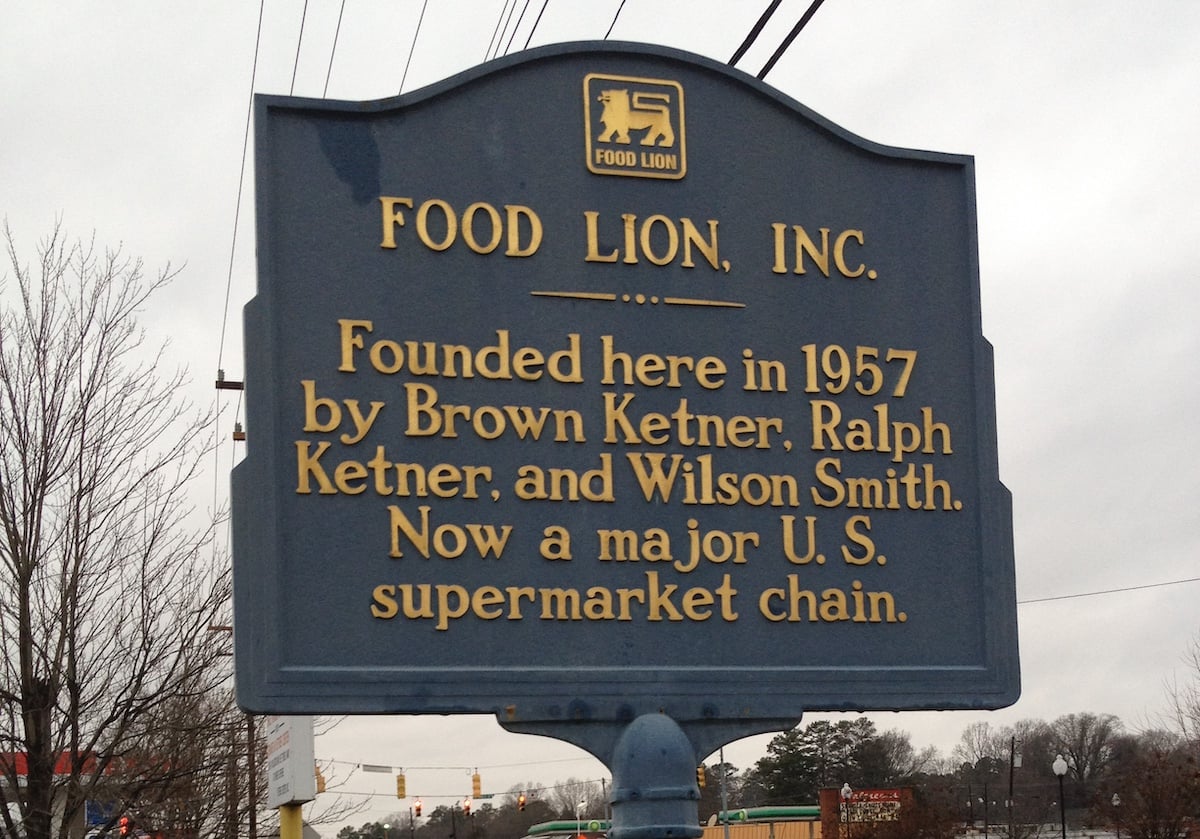 A blue and gold historical marker for Food Lion, Inc., one of the notable companies founded by year in 1957 by Brown Ketner, Ralph Ketner, and Wilson Smith, now a major U.S. supermarket chain.