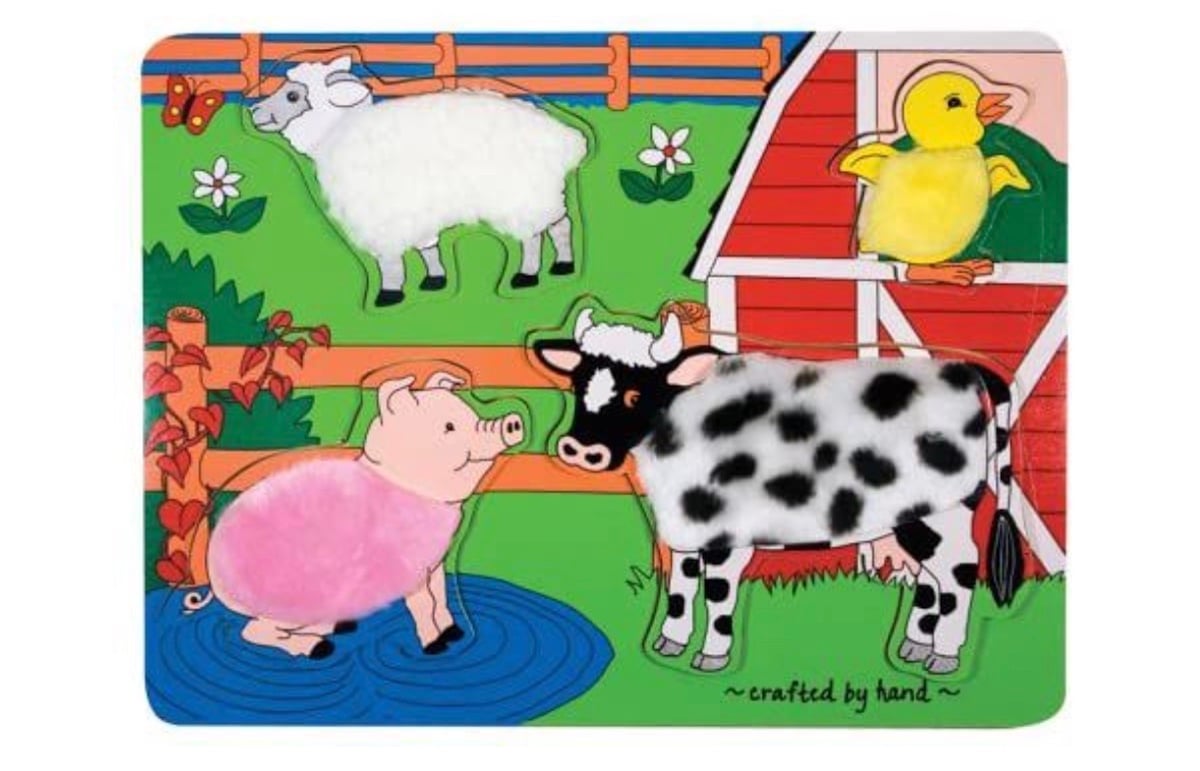 Colorful children’s puzzle showing a pig, sheep, cow, and chick with textured fur and feathers on a farm scene—perfect for little ones learning about animals and companies founded by year. Features grass, flowers, a wooden fence, and a red barn in the background.