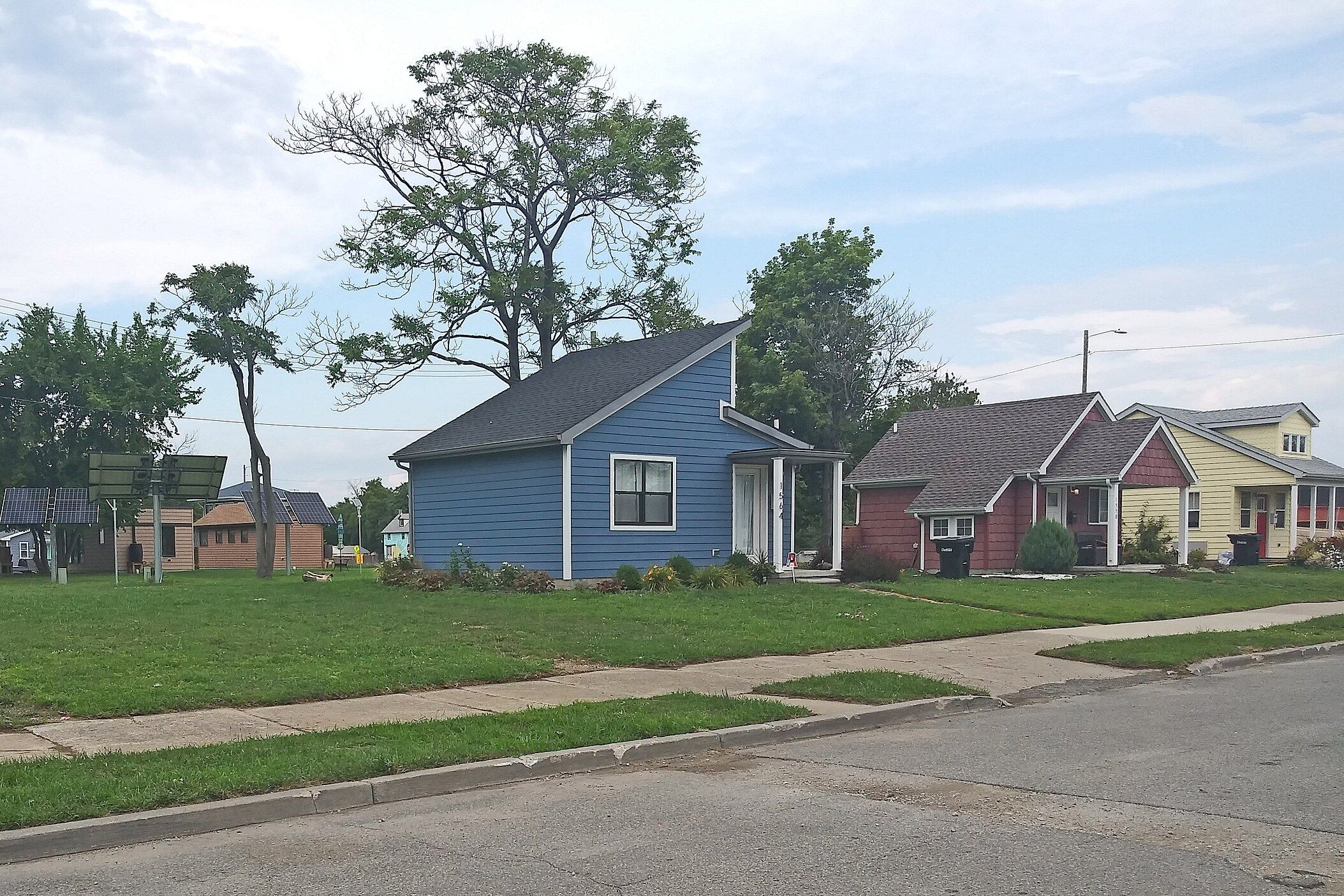 Several tiny homes in the community built by Cass Community Social Services, Detroit with lawn, trees scattered about