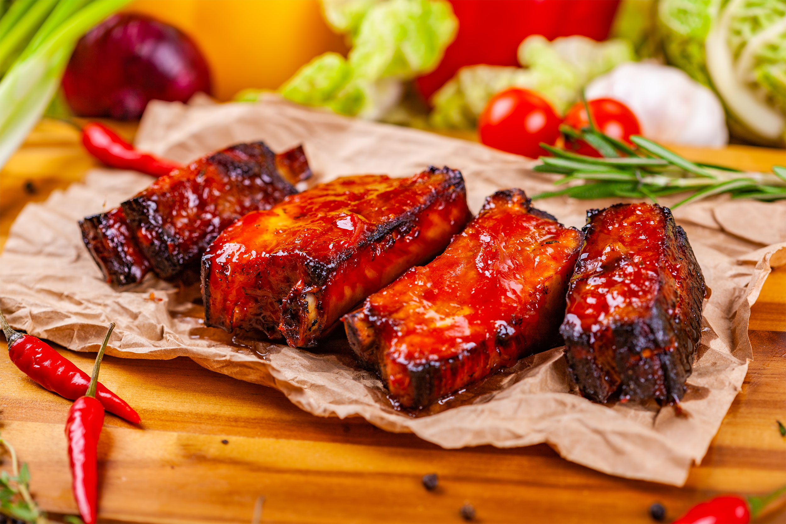 Bright Red Chinese barbecue ribs surrounded by peppers and vegetables