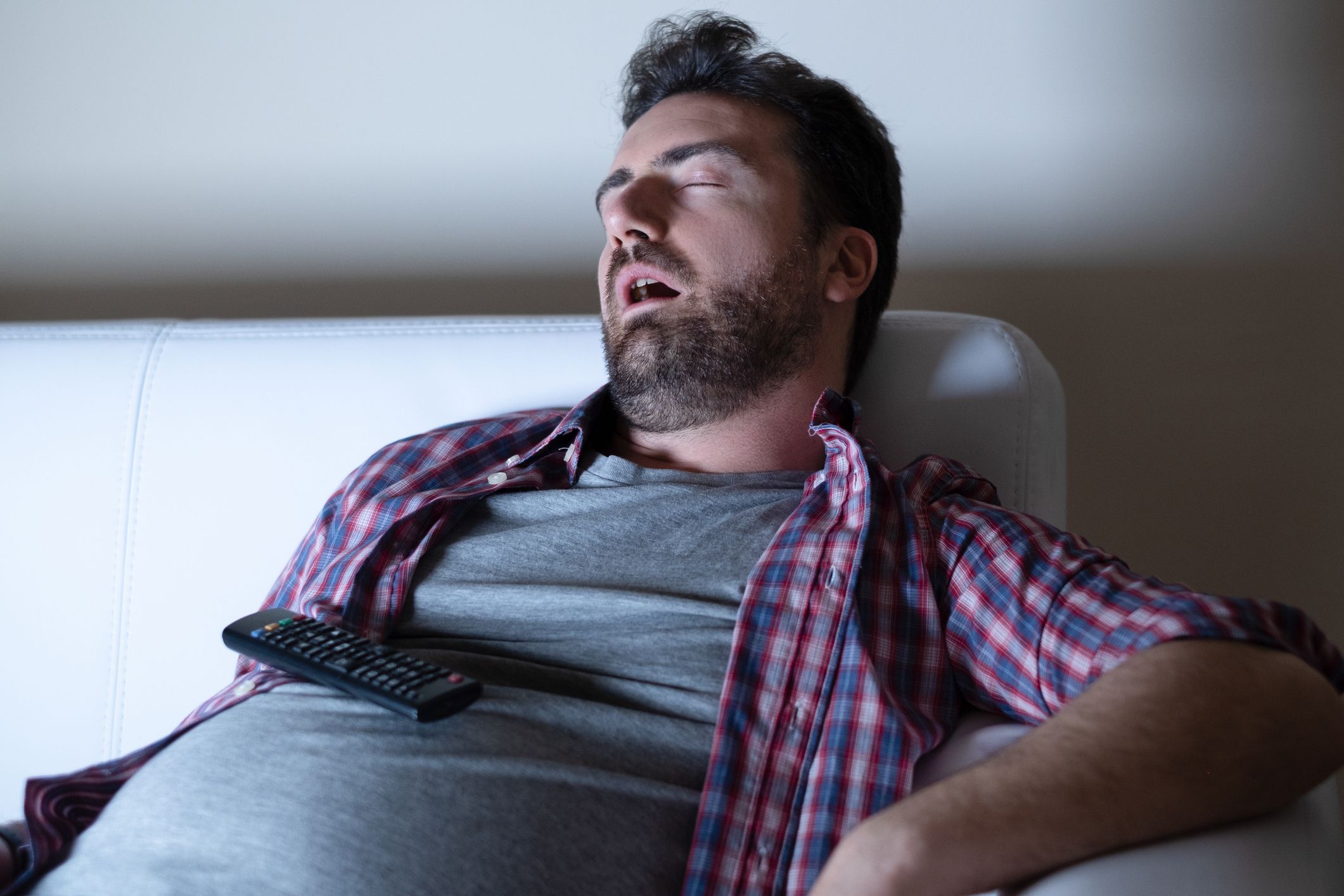 Lazy man watching television at night alone