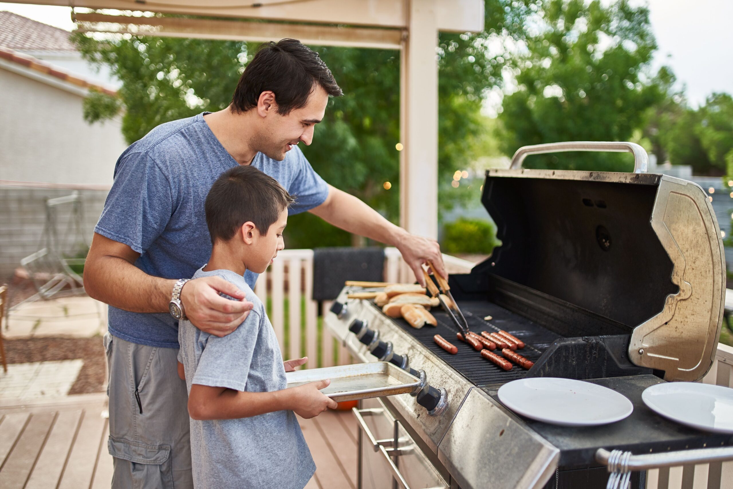 father and son grilling hot dogs