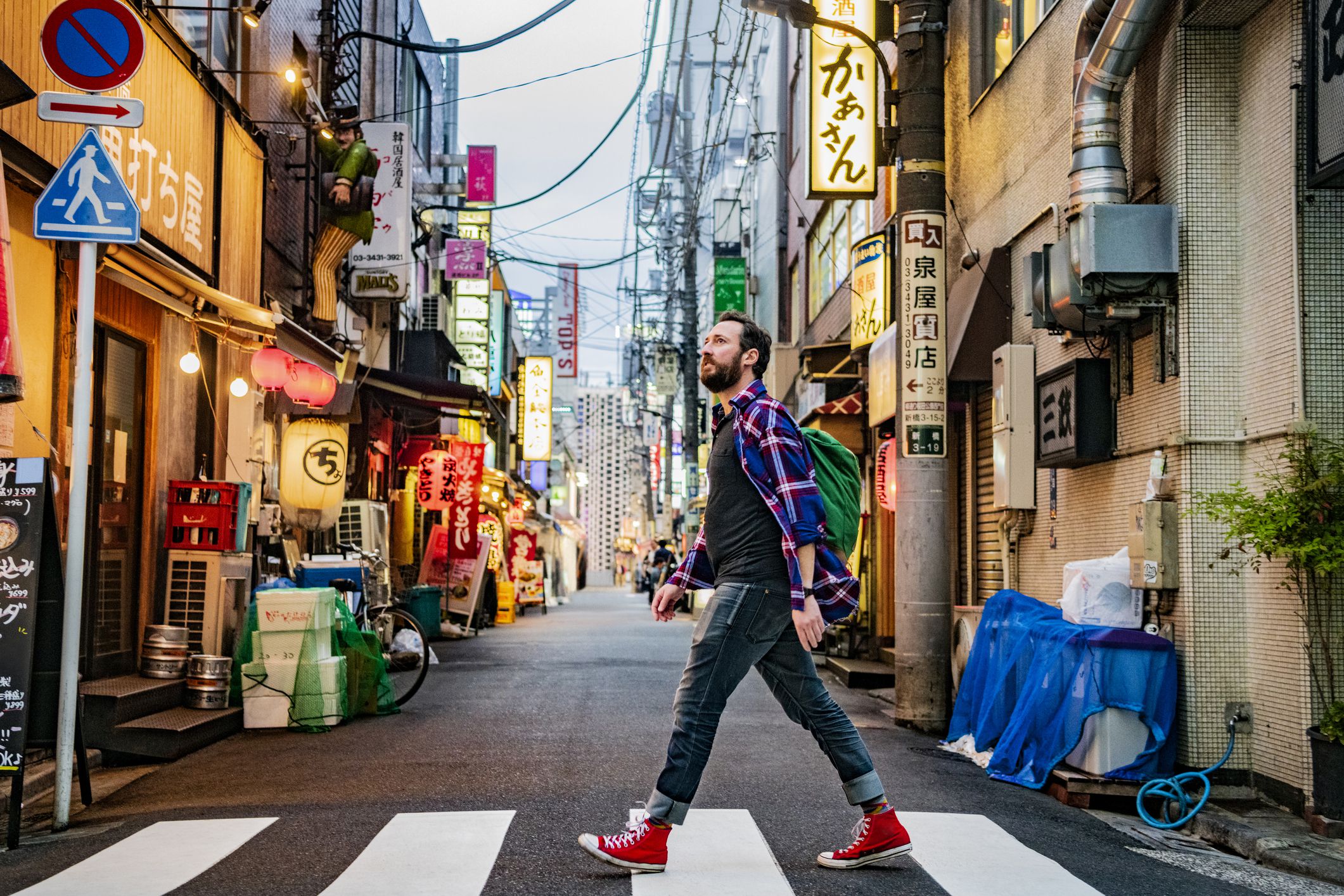 Backpacker crossing road on urban street, sight seeing, exploration, cool