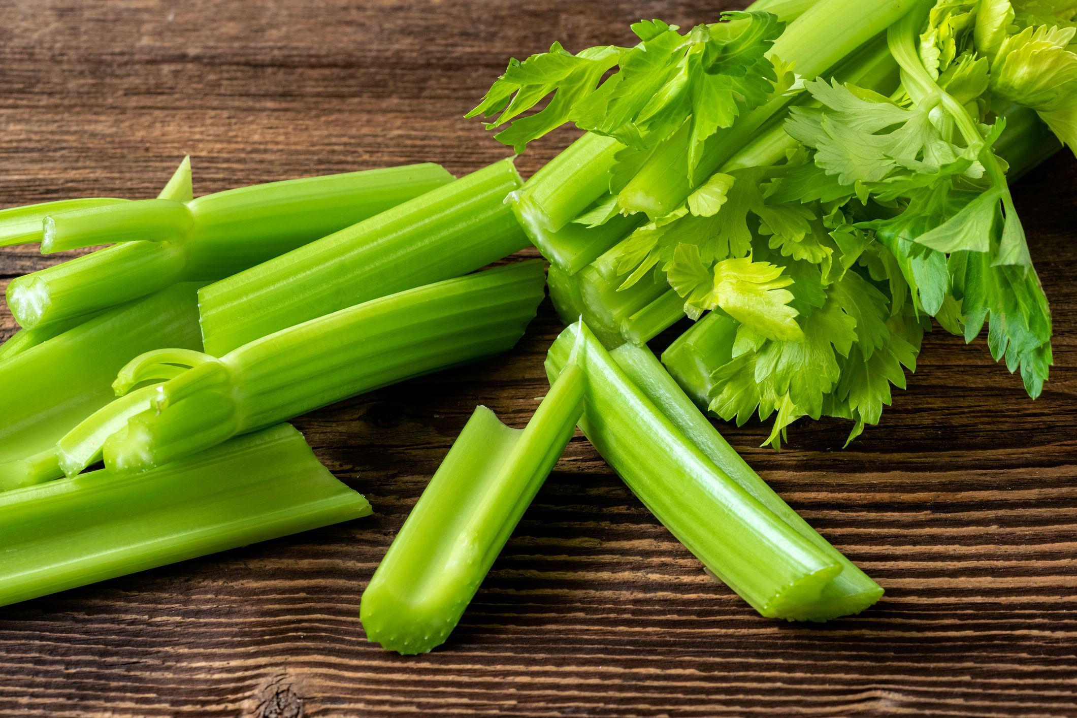 Cut celery sticks and leaves on wooden table