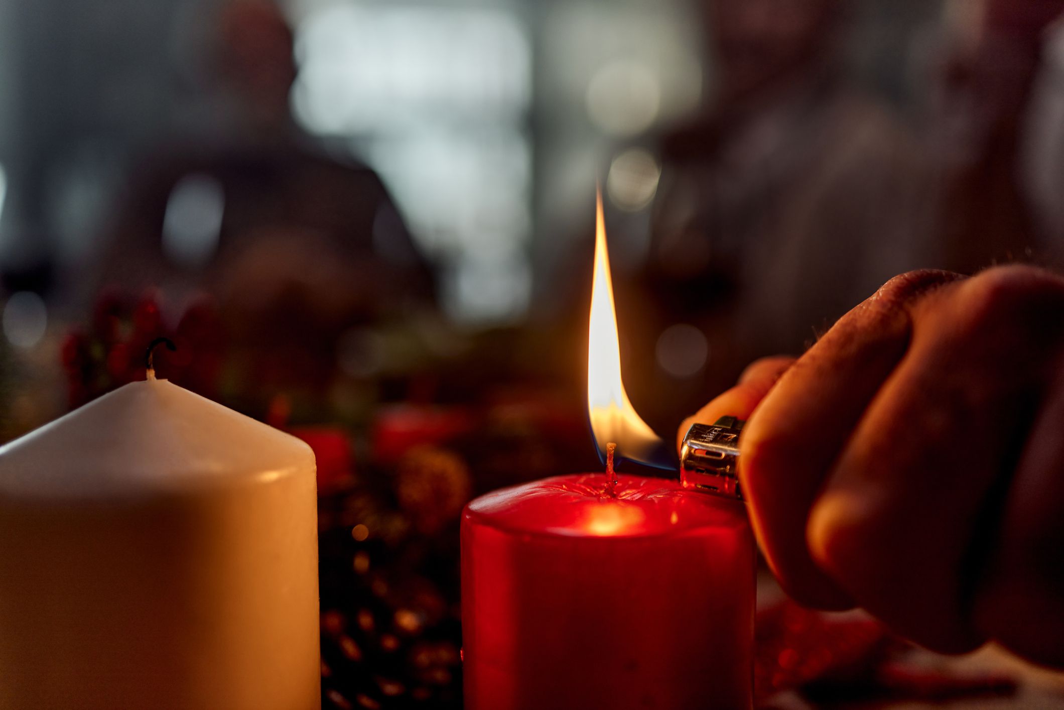 Close up of unrecognizable person lighting a candle.