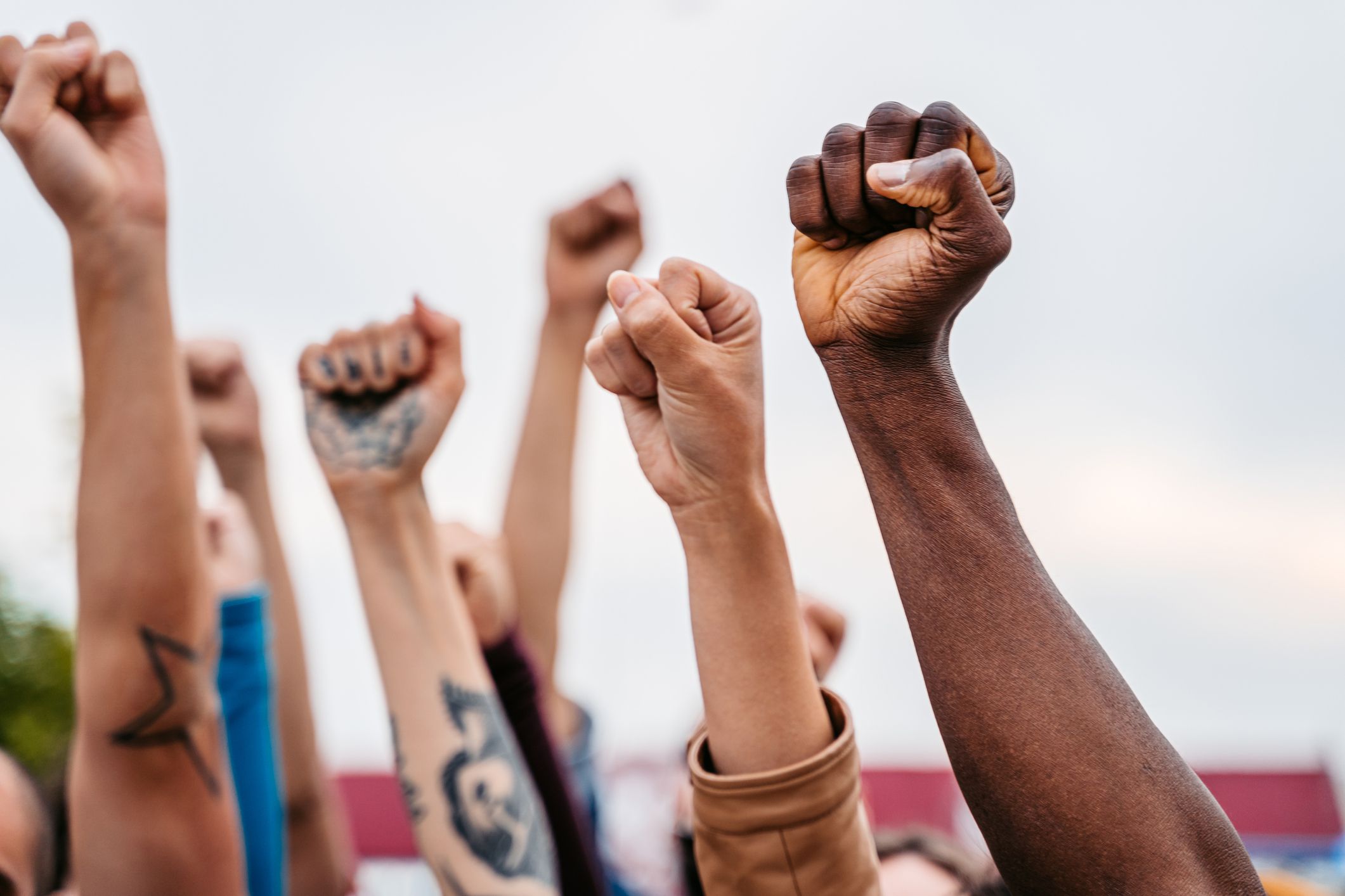 Close-up of protestors raising hands above their heads.
