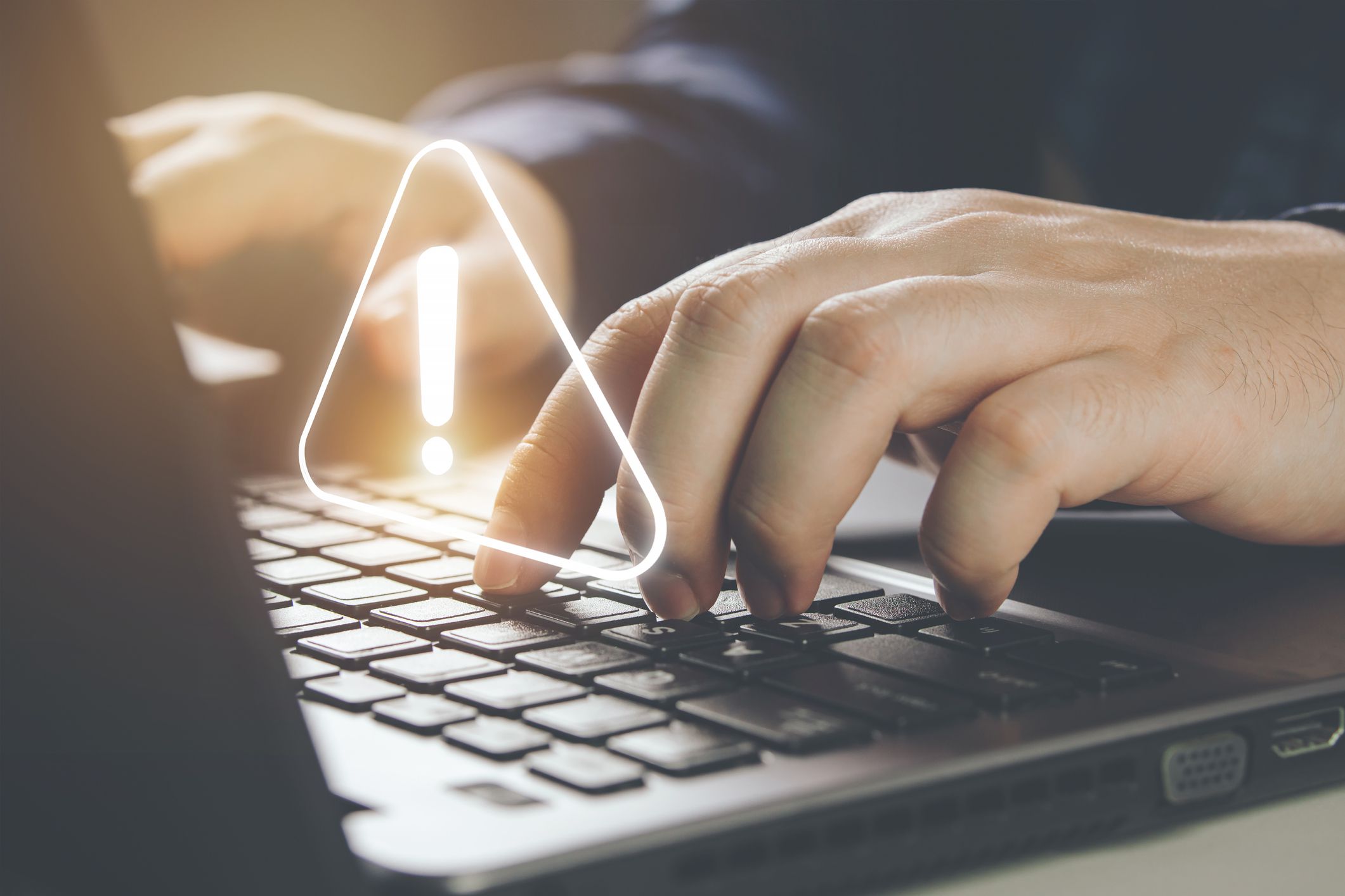 Businessman using laptop computer with alerts, warning triangles showing system errors. Concept of system maintenance, security, virus protection and hacking prevention accessing important information.