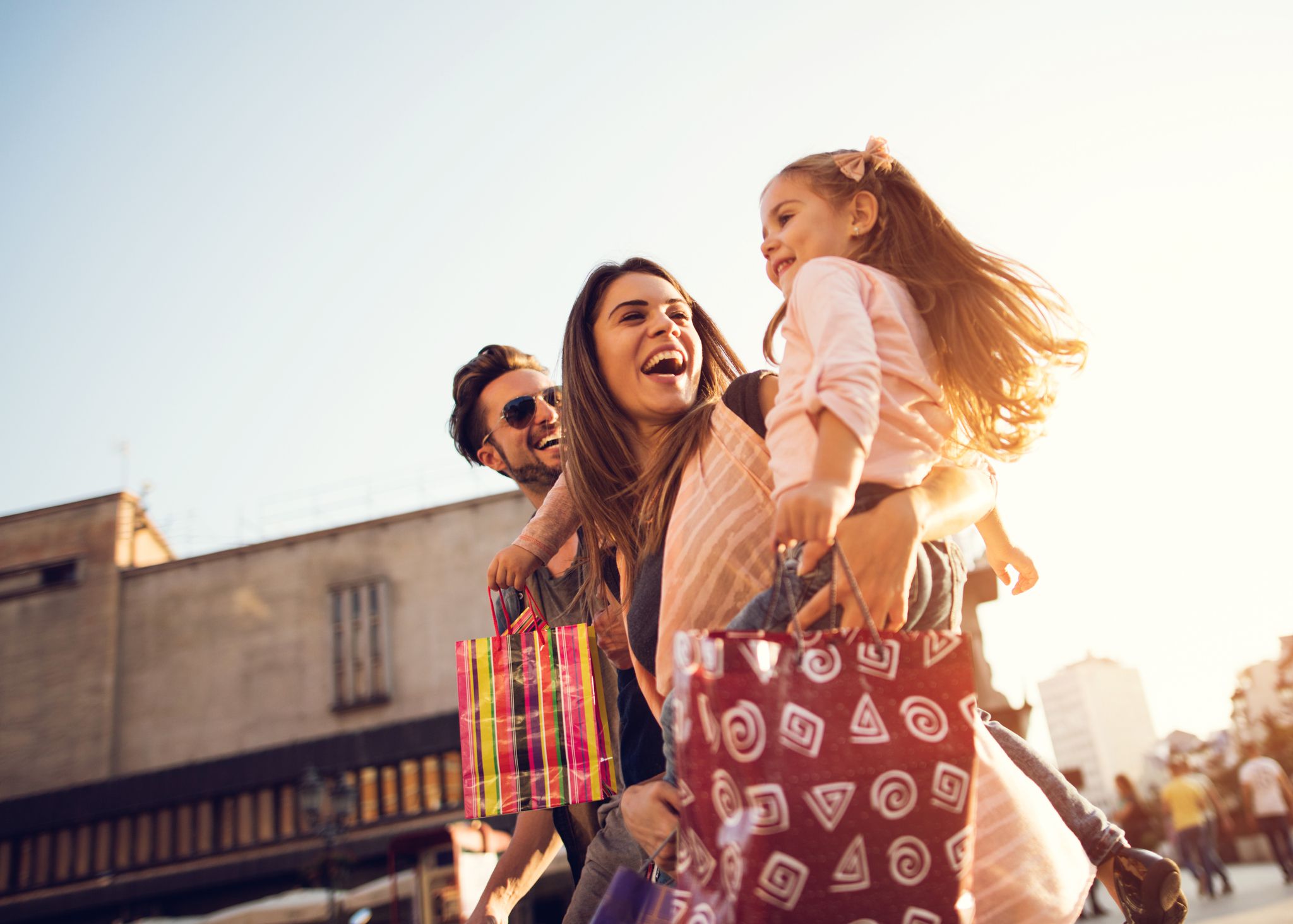 Low angle view of cheerful family having fun during a shopping day in the city.