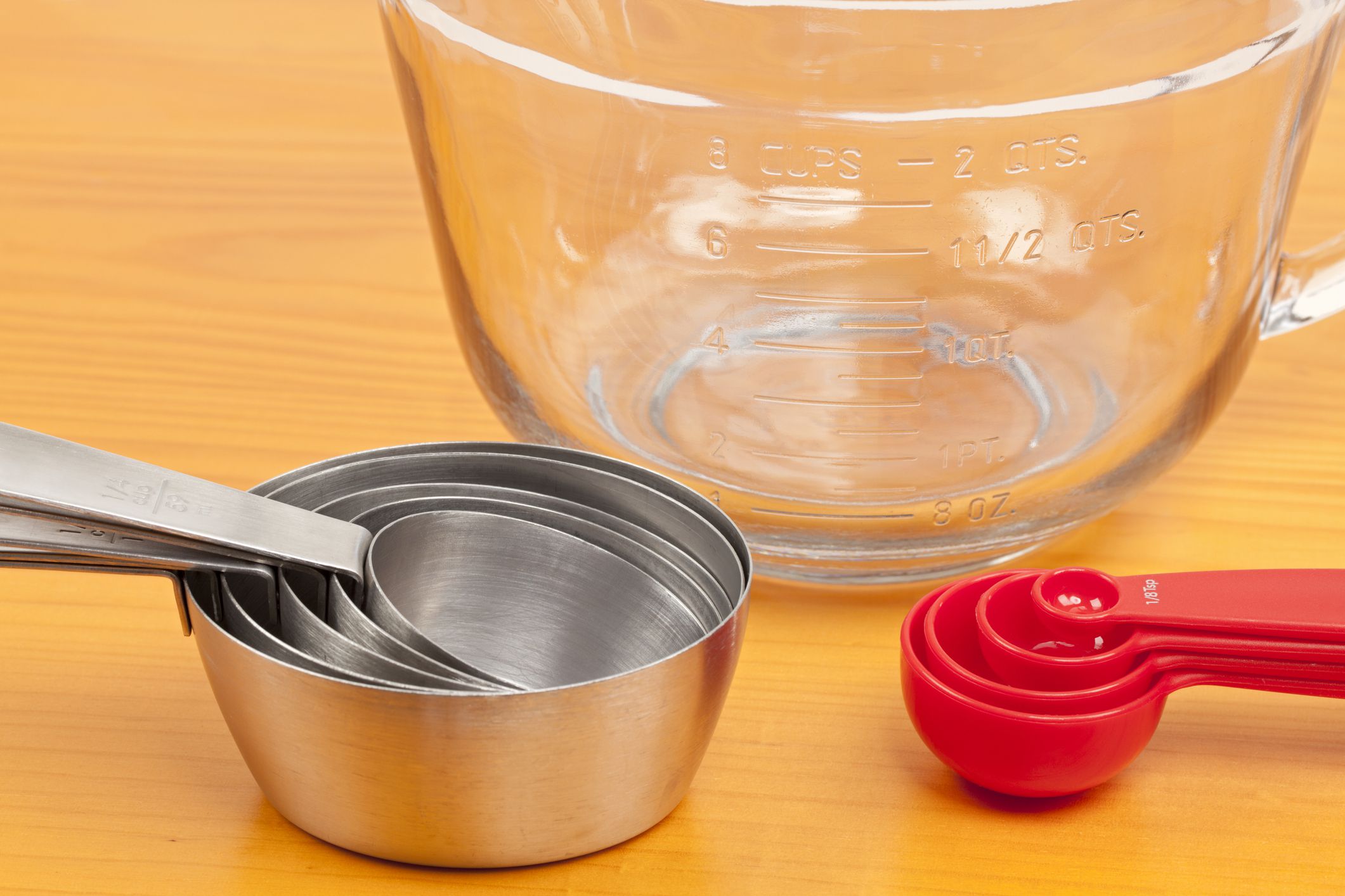 Empty measuring cups on a wooden tabletop.