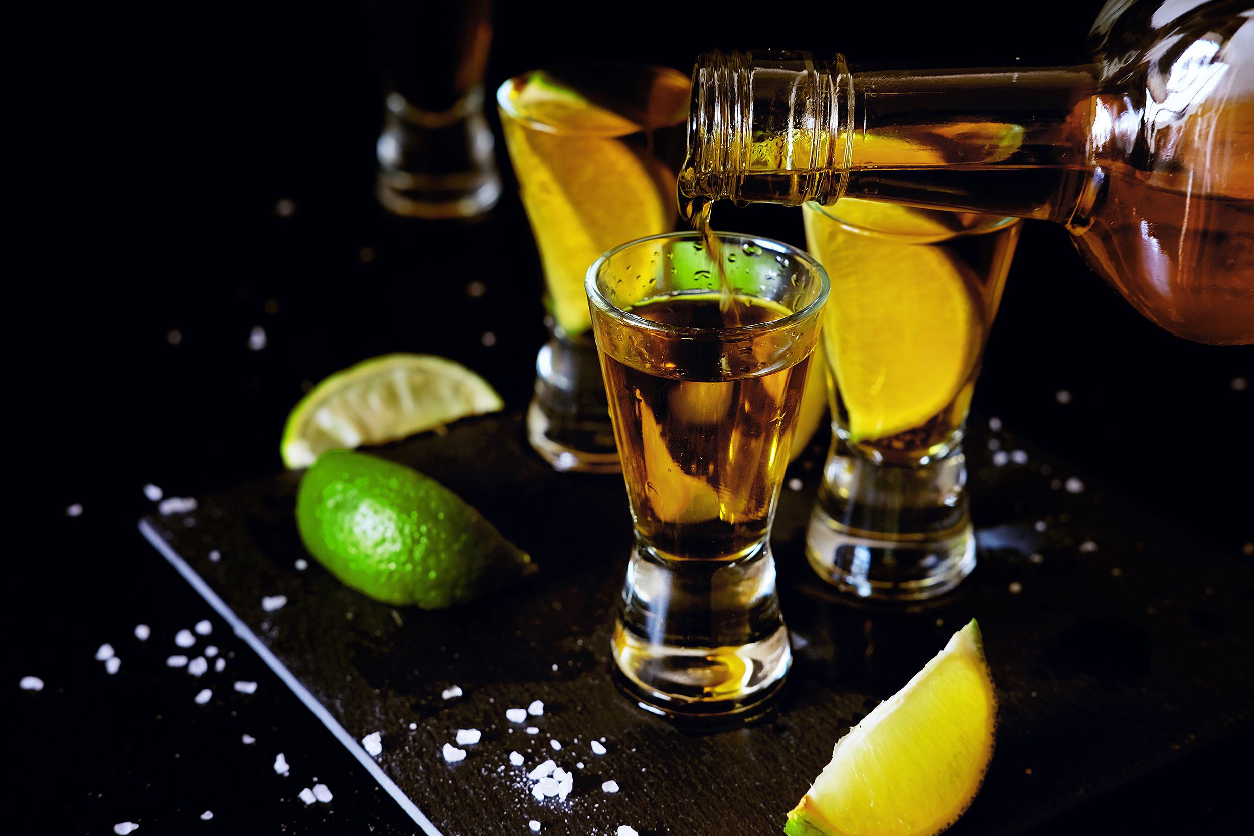 reposado tequila glass shots in the bar with salt and lime slices