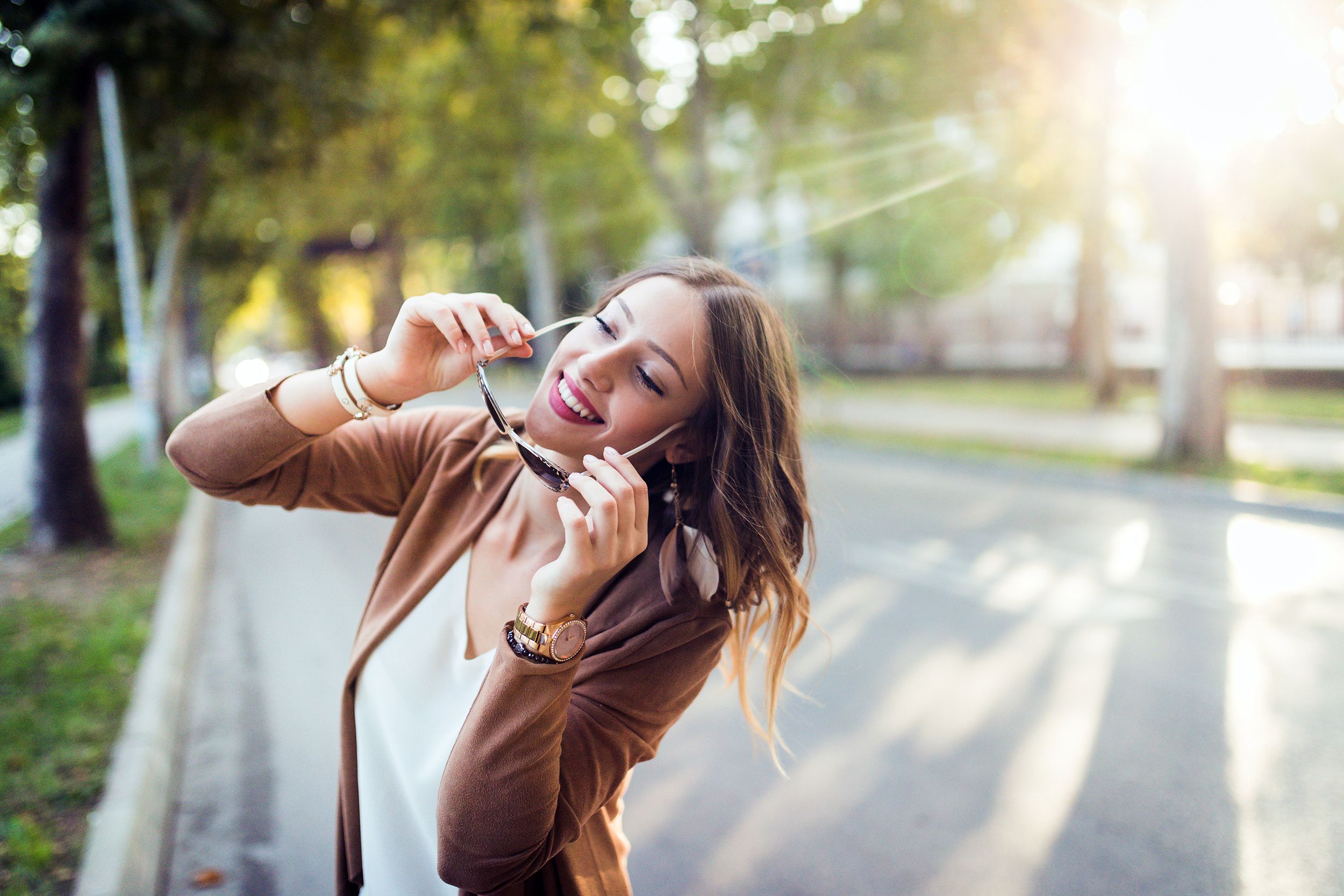 woman putting on sunglasses while outside