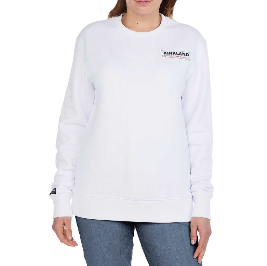 Woman wearing white sweater with Kirkland logo