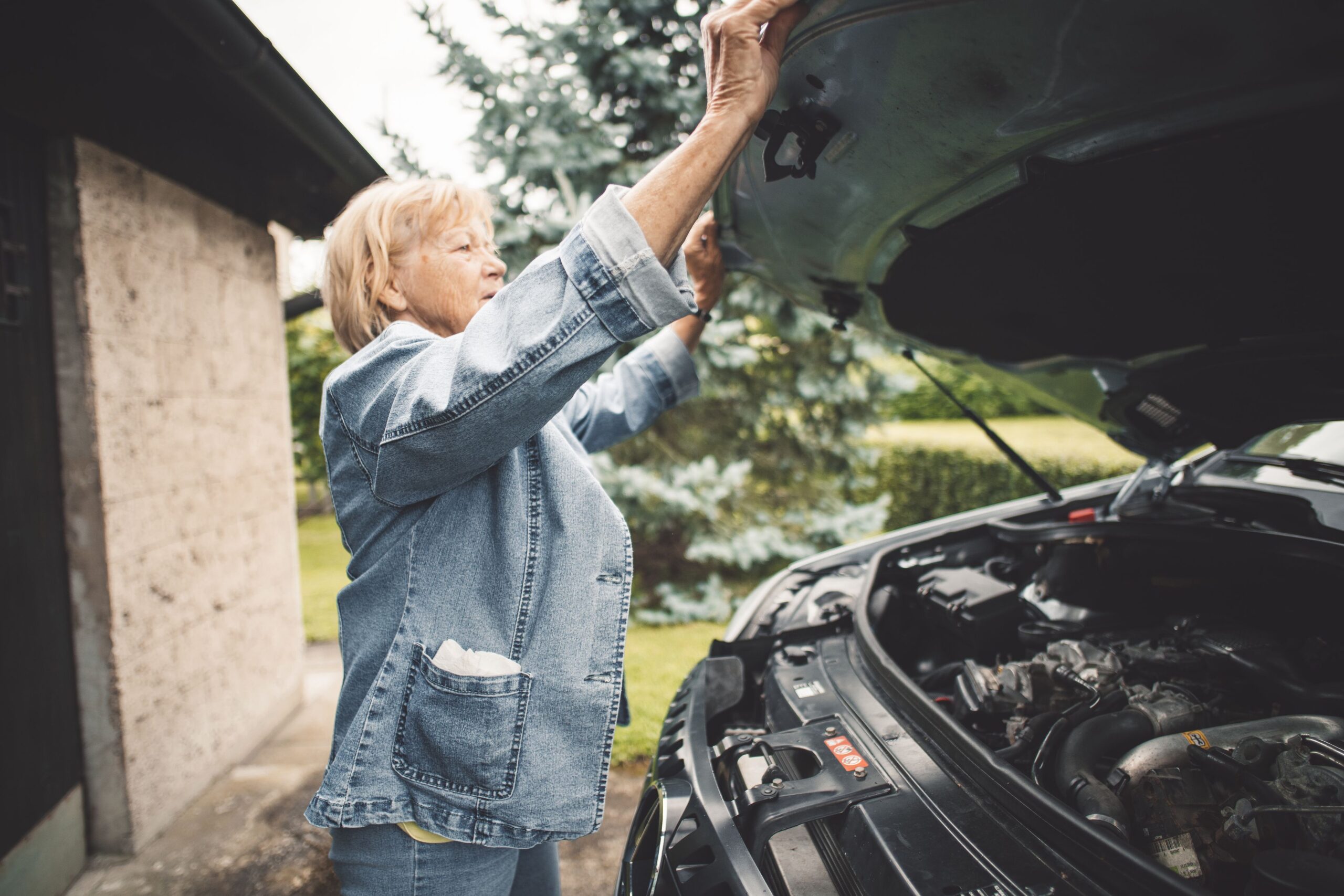 Woman opening front hood of her car
